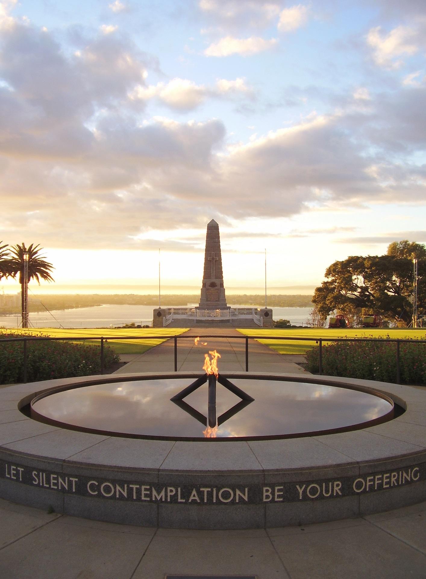 An outdoor memorial structure at sunrise. 