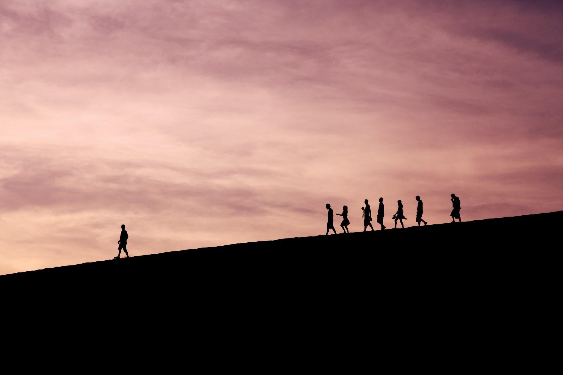 Silhouette of a group of people on a hill.