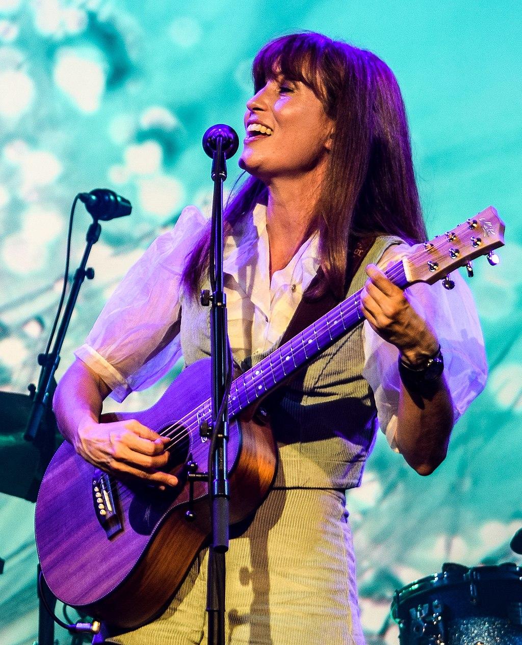 Photo of Missy Higgins singing and playing guitar on stage
