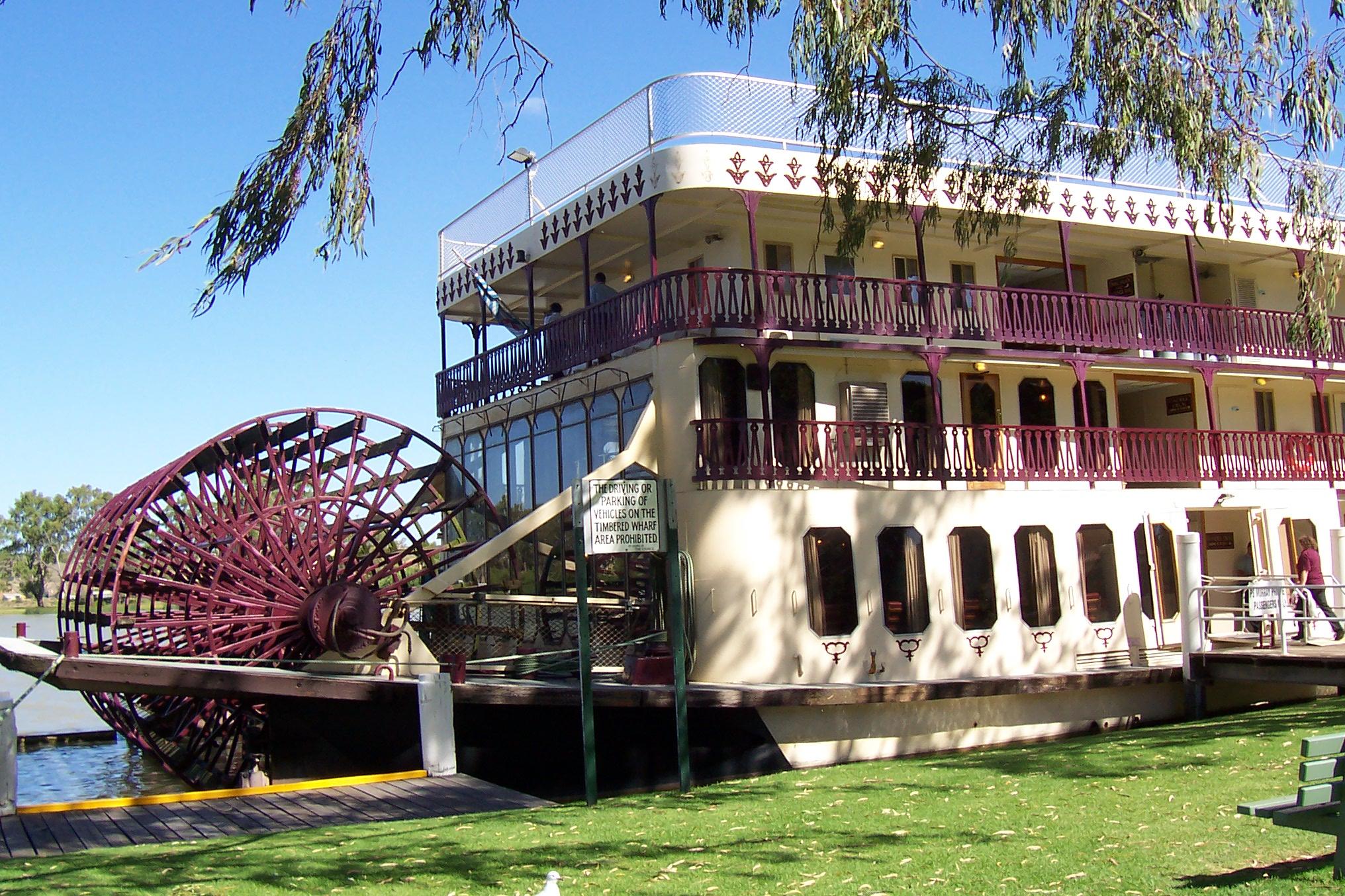 A paddle boat with purple trim on a sunny day. 