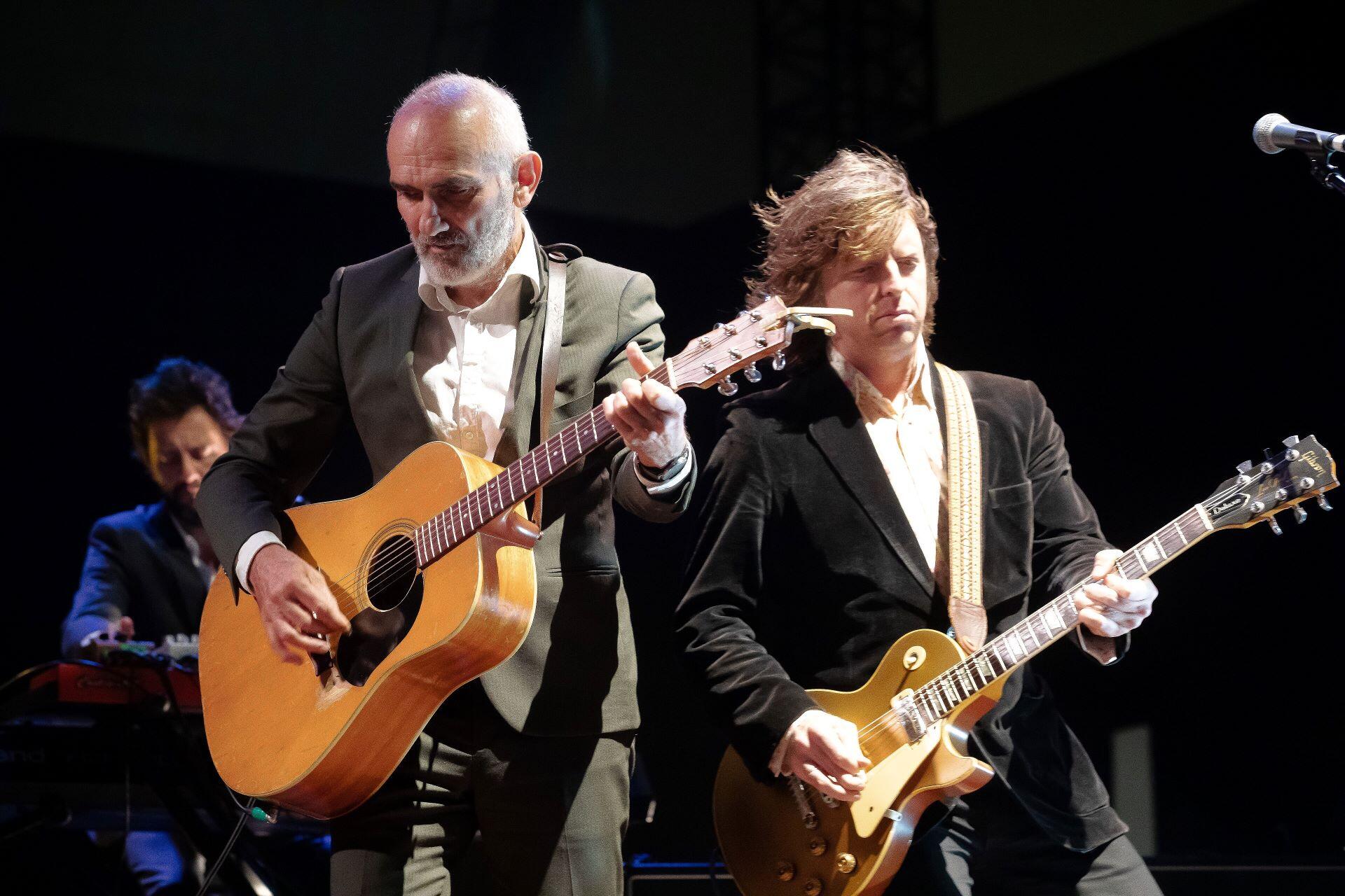 Paul Kelly playing guitar during a live performance