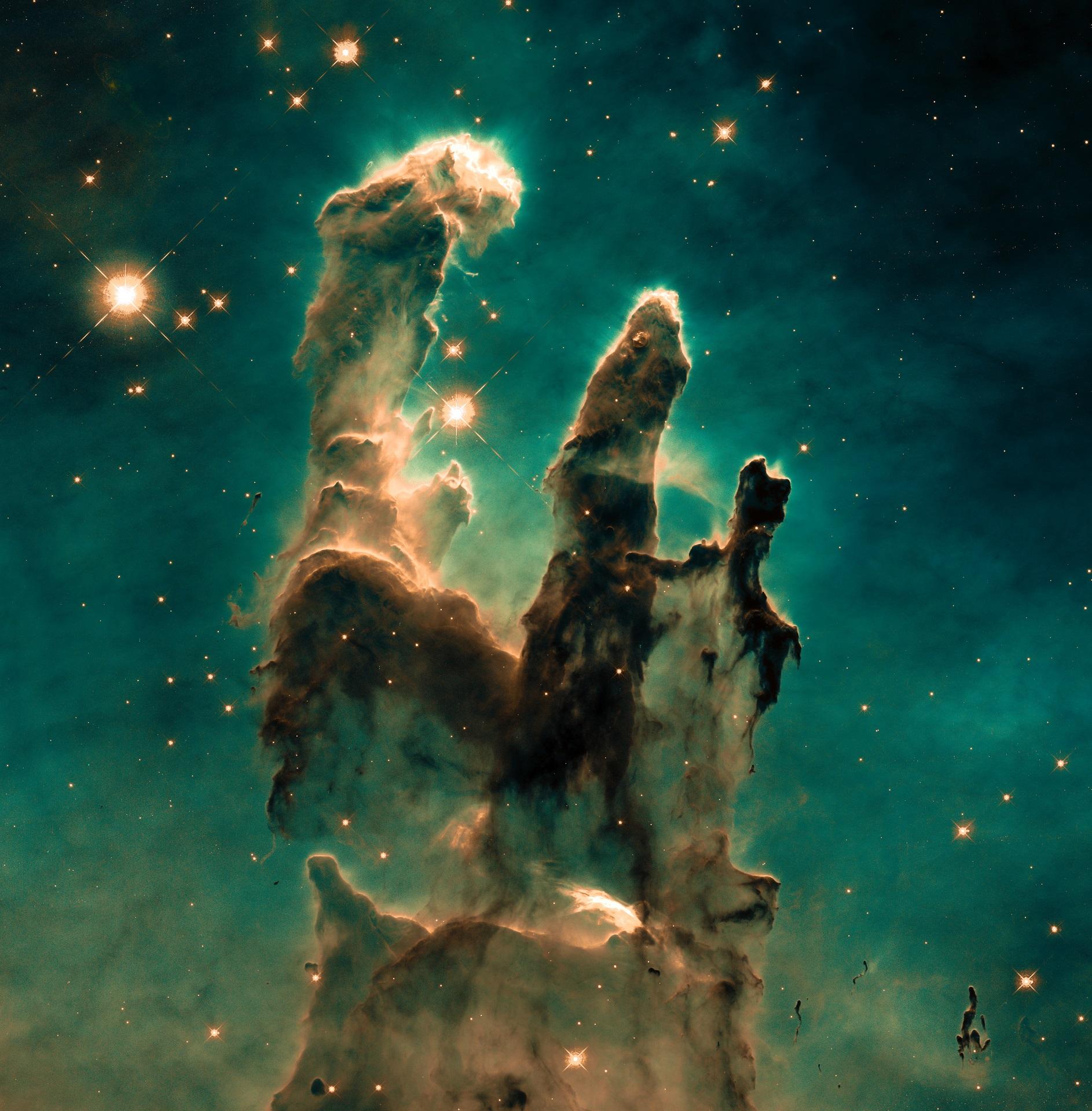 Three gas pillars surrounded by stars against a green background.