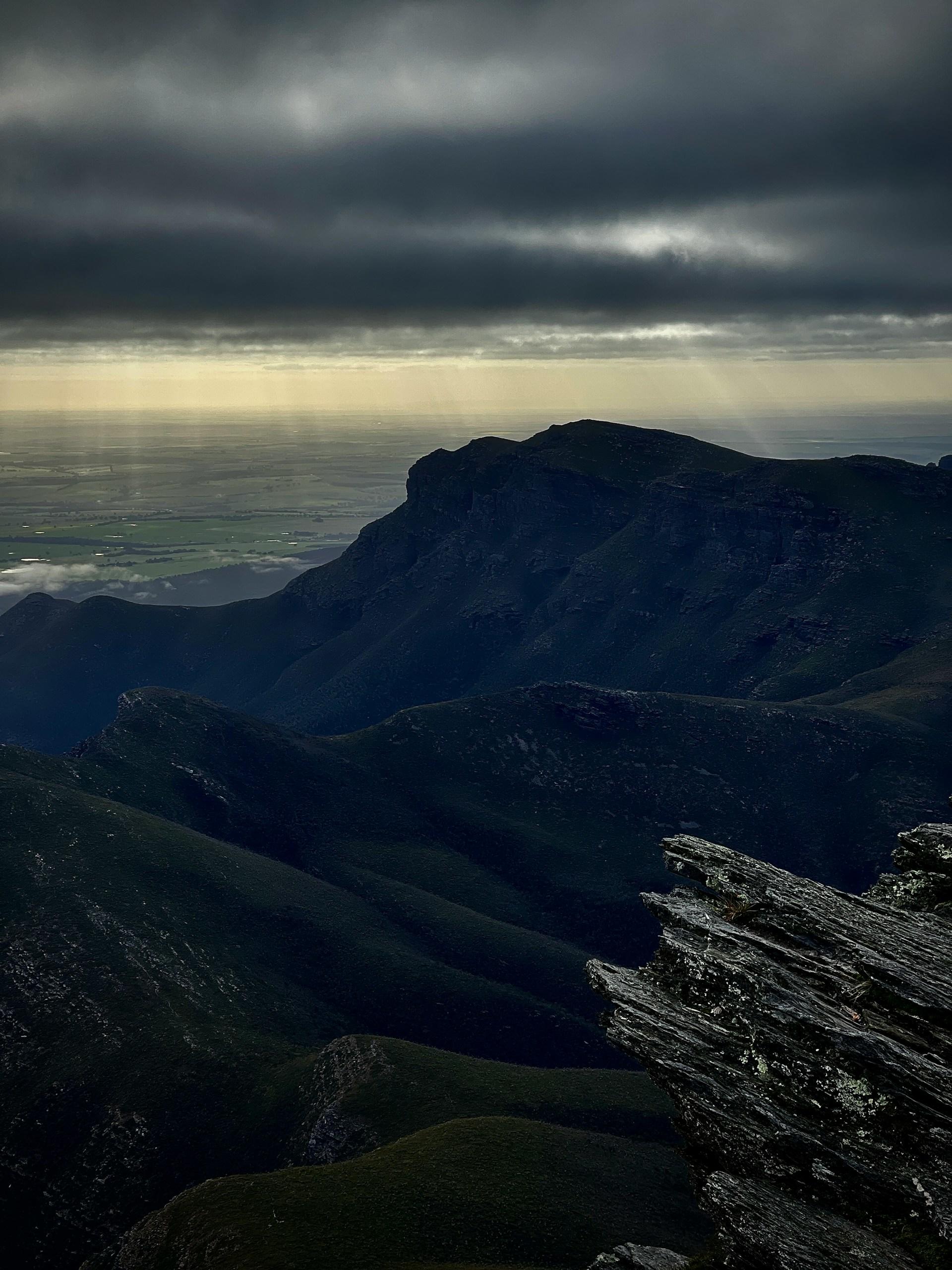 A mountain range at sunset on a cloudy day. 