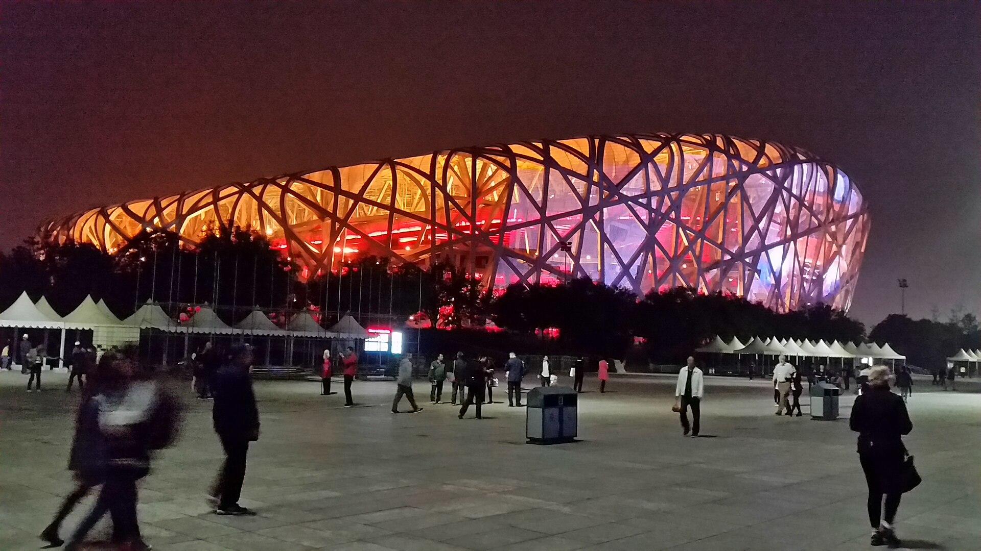 A building lit up with orange and pink lights at night.