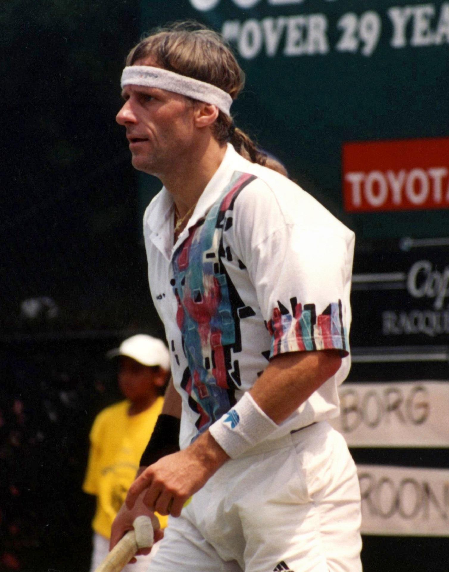 A man wearing a button-down shirt and a headband on a sunny day.