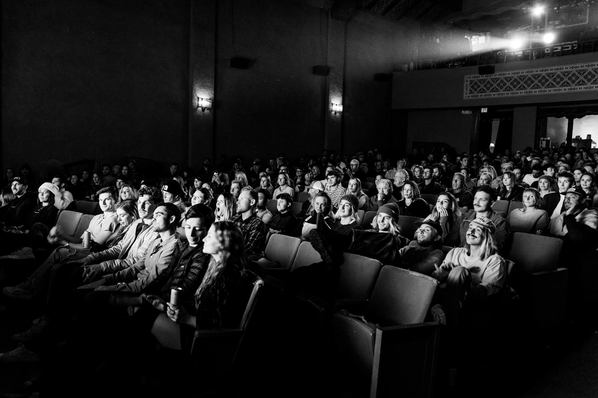 A black and white photo of people in a cinema.