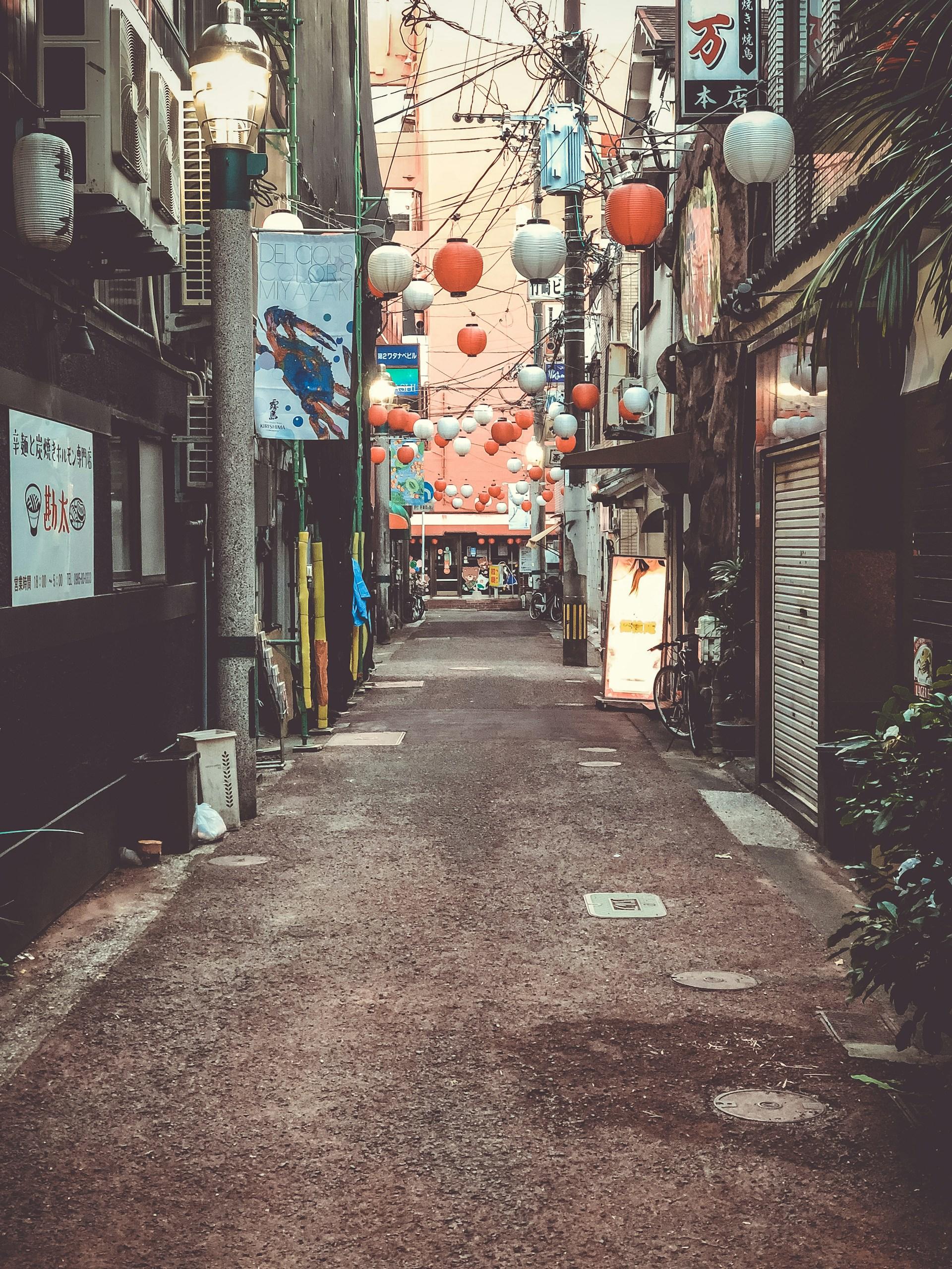 An alleyway with many lanterns and balloons decorating it. 