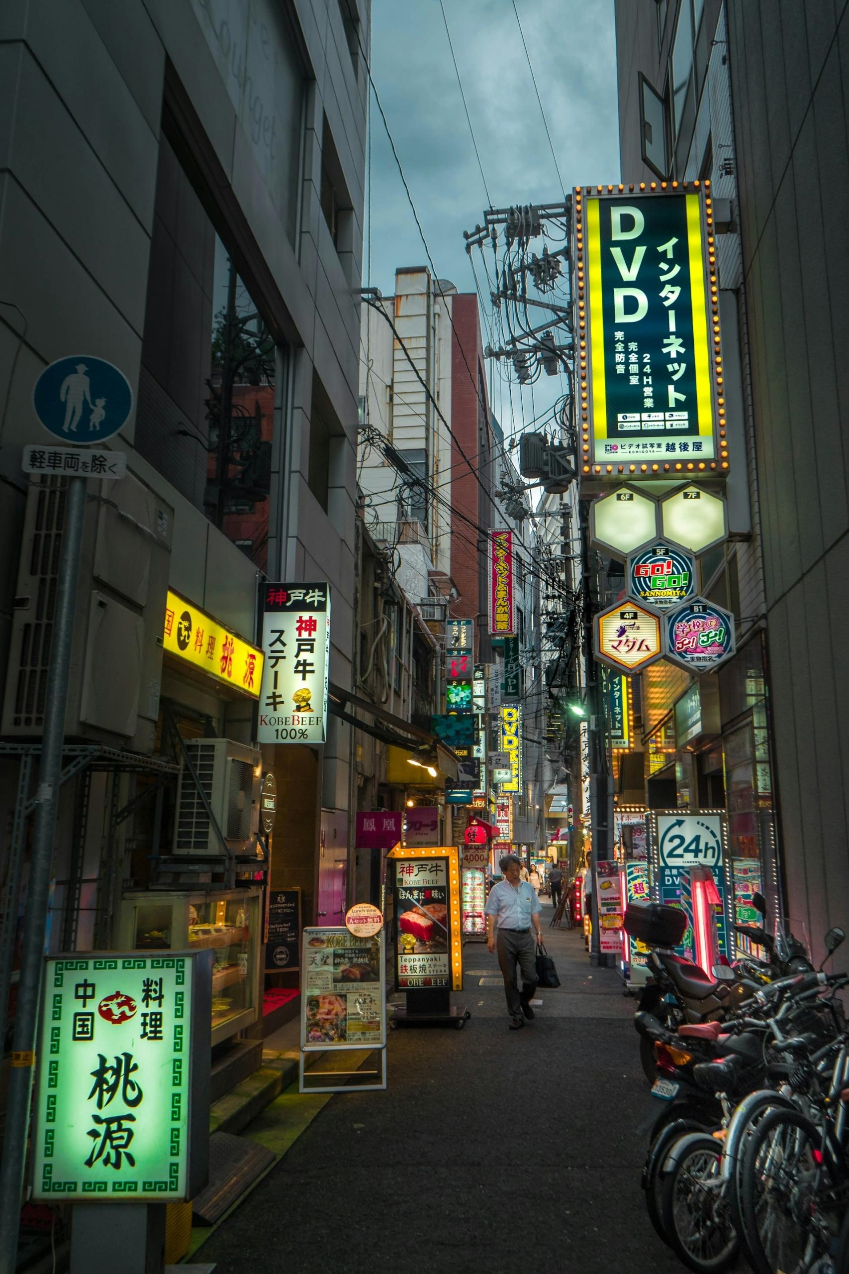 An alleyway at dusk lit up with neon signs. 