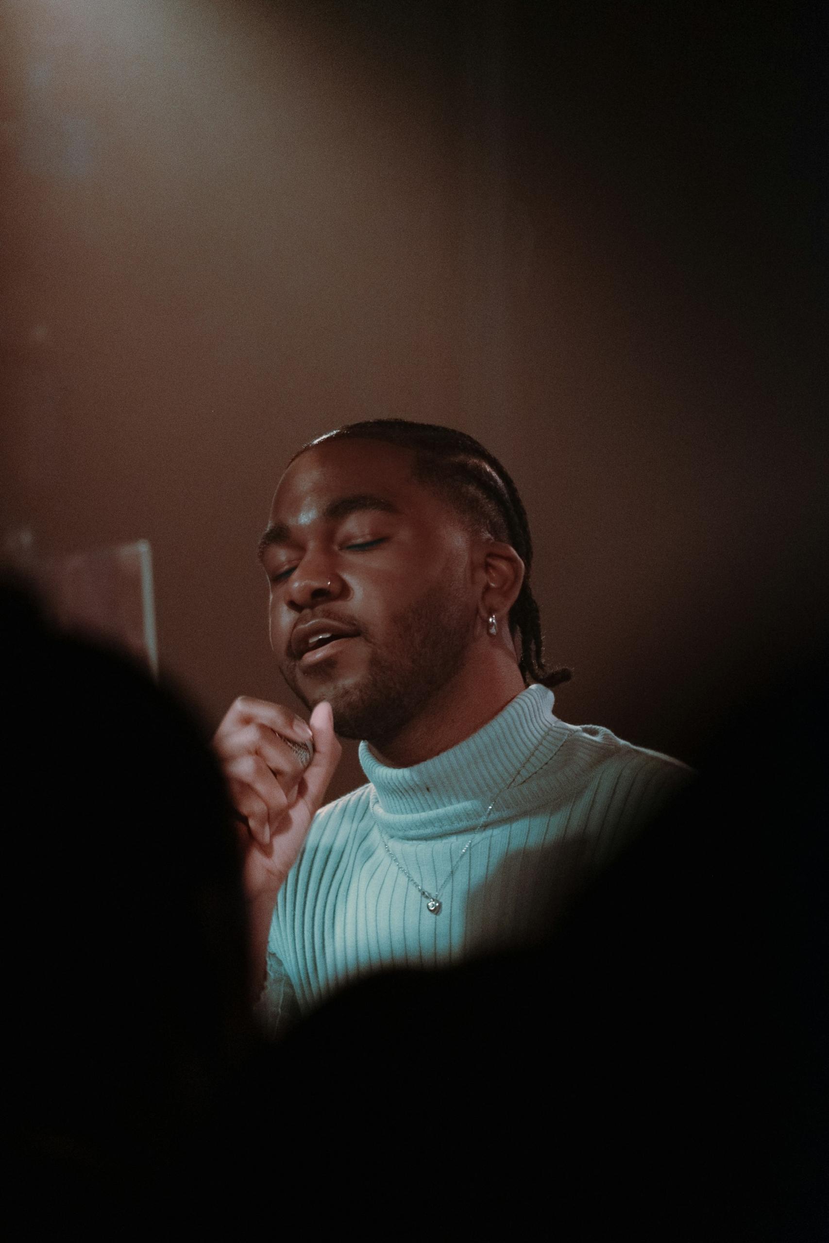 A man in a white shirt with his eyes closed.