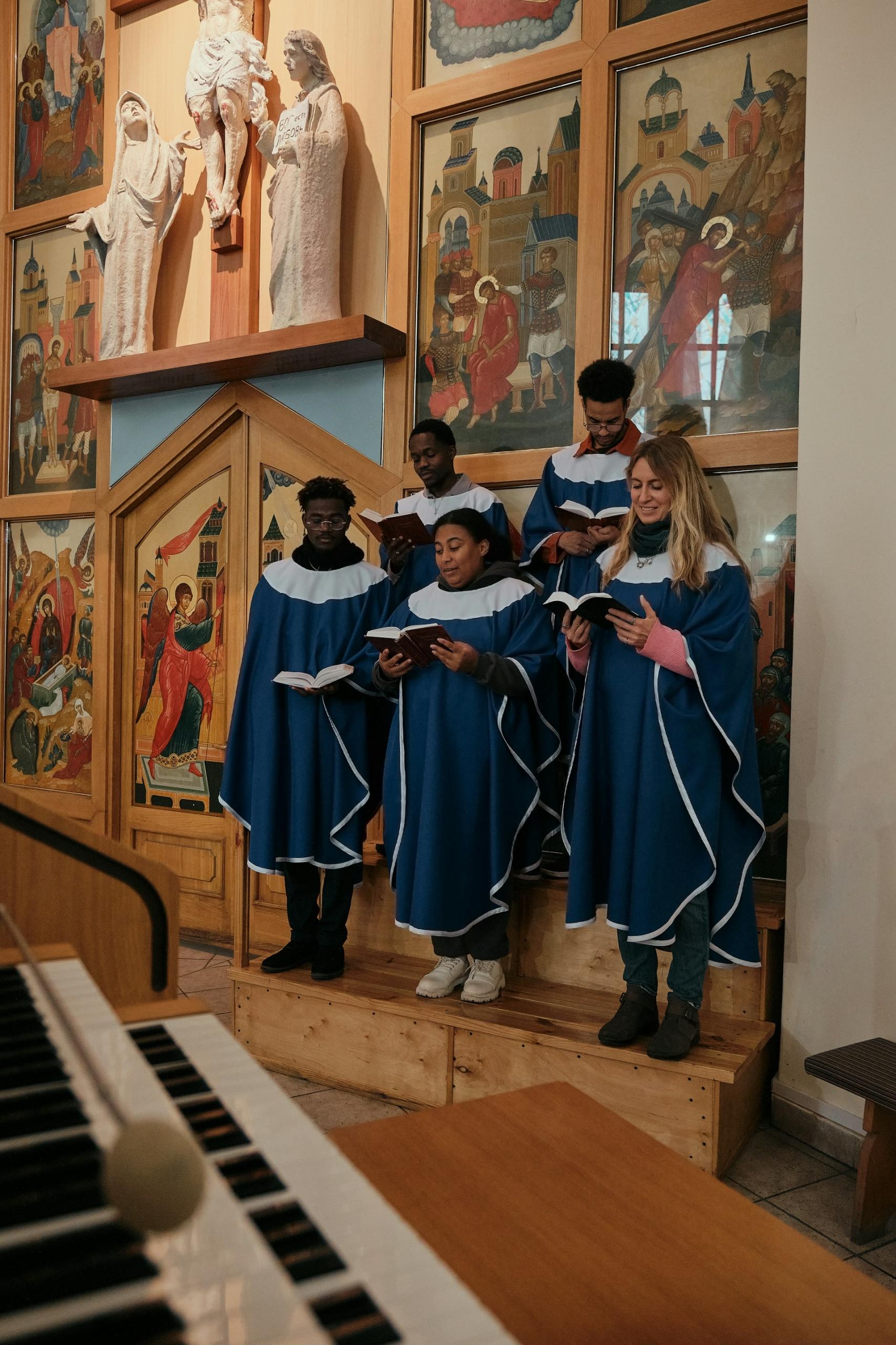 A group of people wearing blue choir dresses with white collars. 