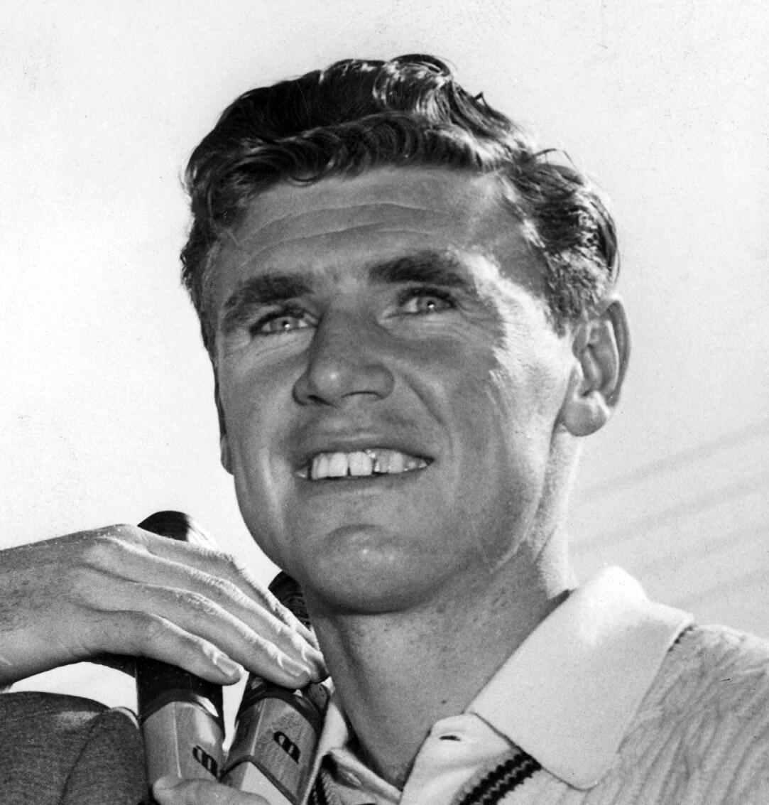 A man holding a tennis racket on a sunny day.