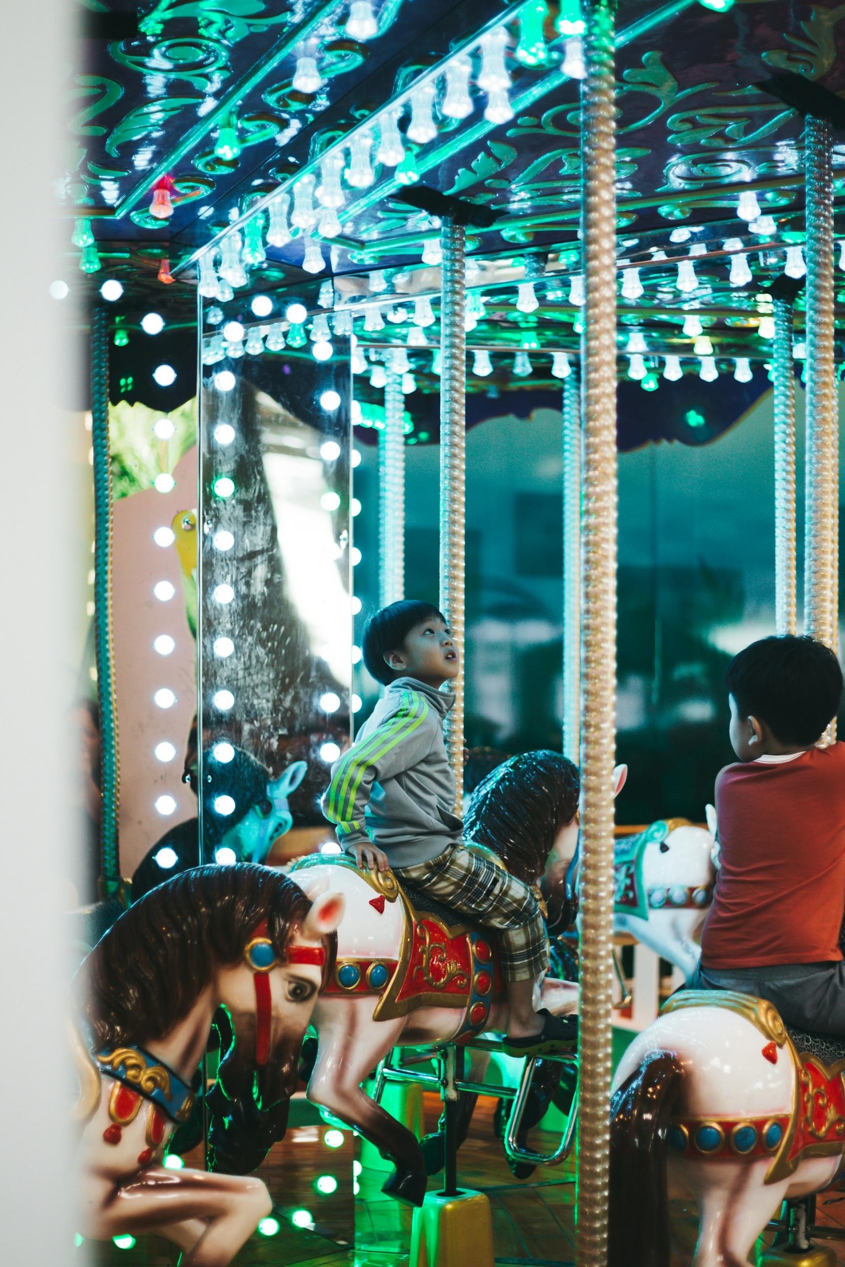 Children ride a carousel. 