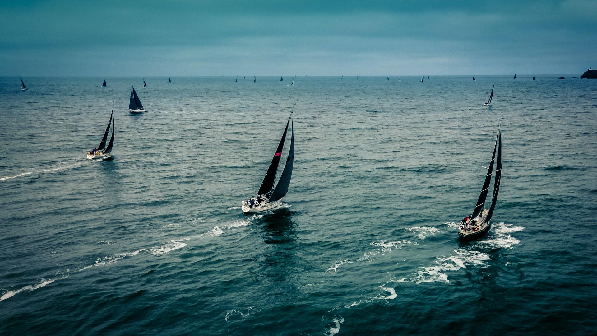 Yachts racing in open water at dawn. 