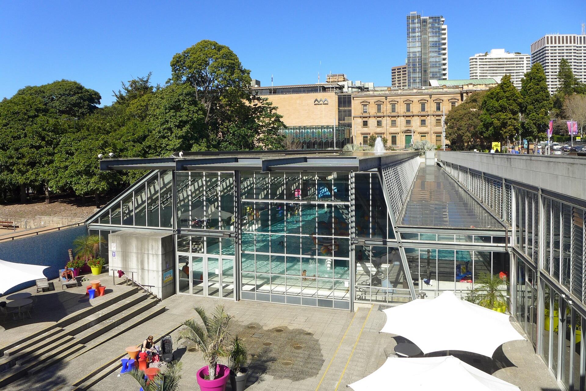An aquatics facility and its surroundings on a sunny day.