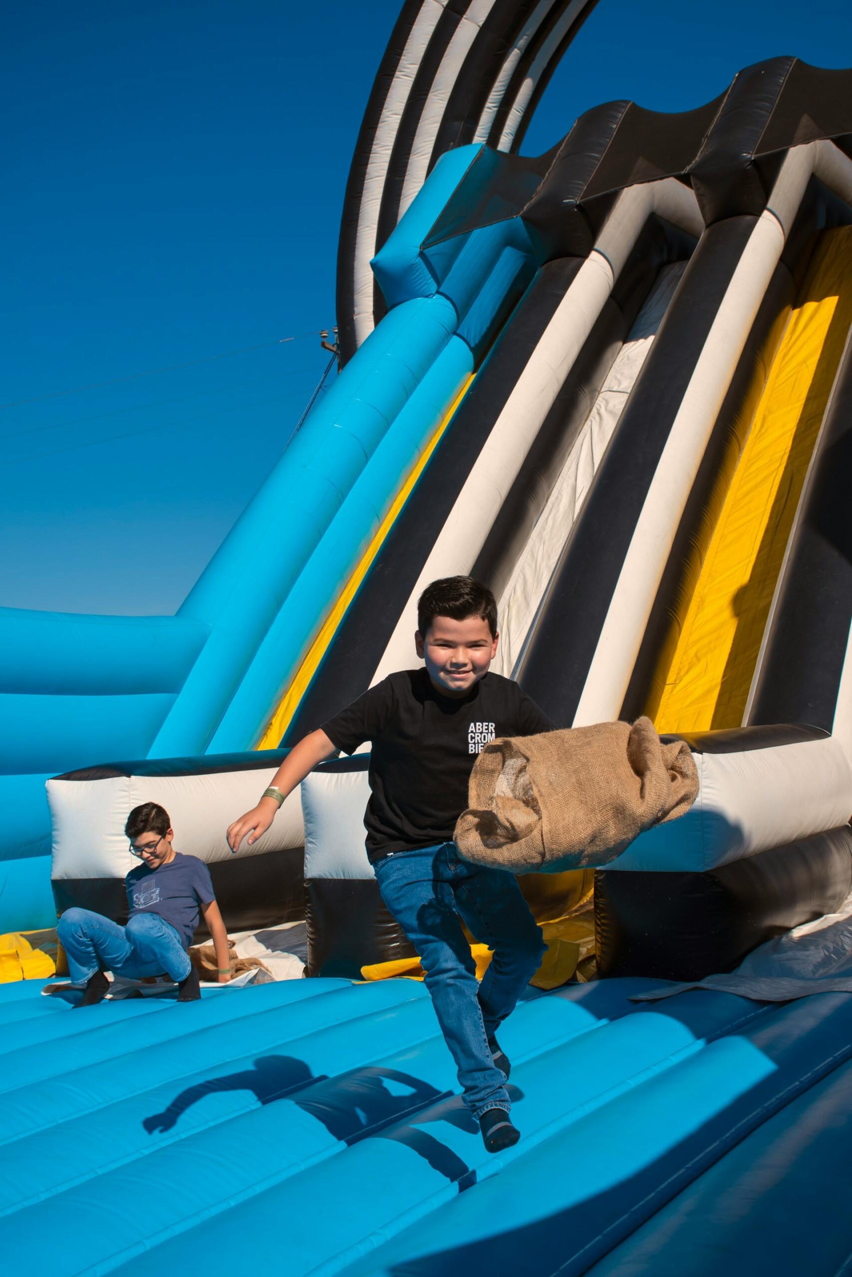 A child on an inflatable challenge installation on a sunny day.