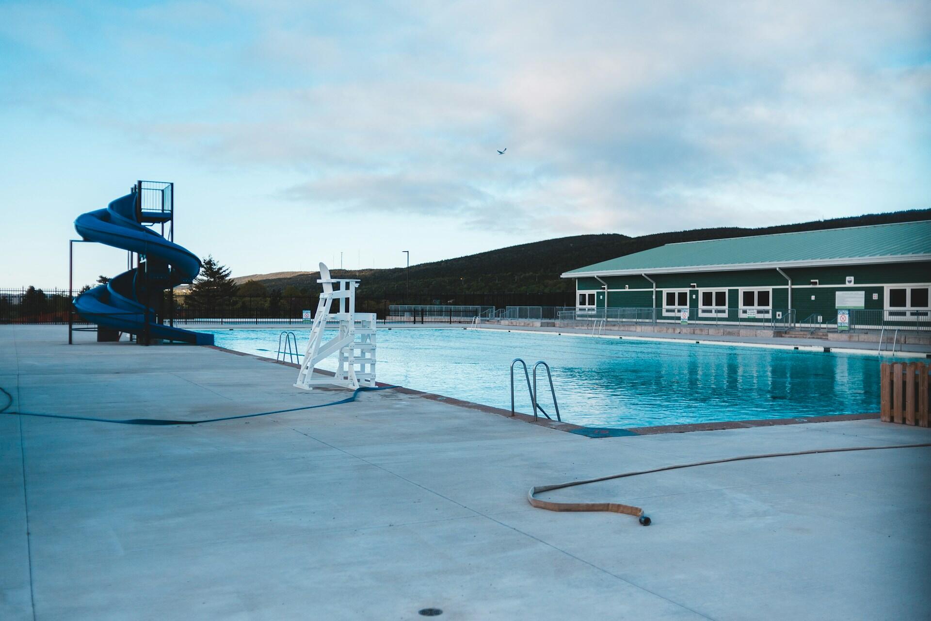 An outdoor swimming pool on a cloudy day.