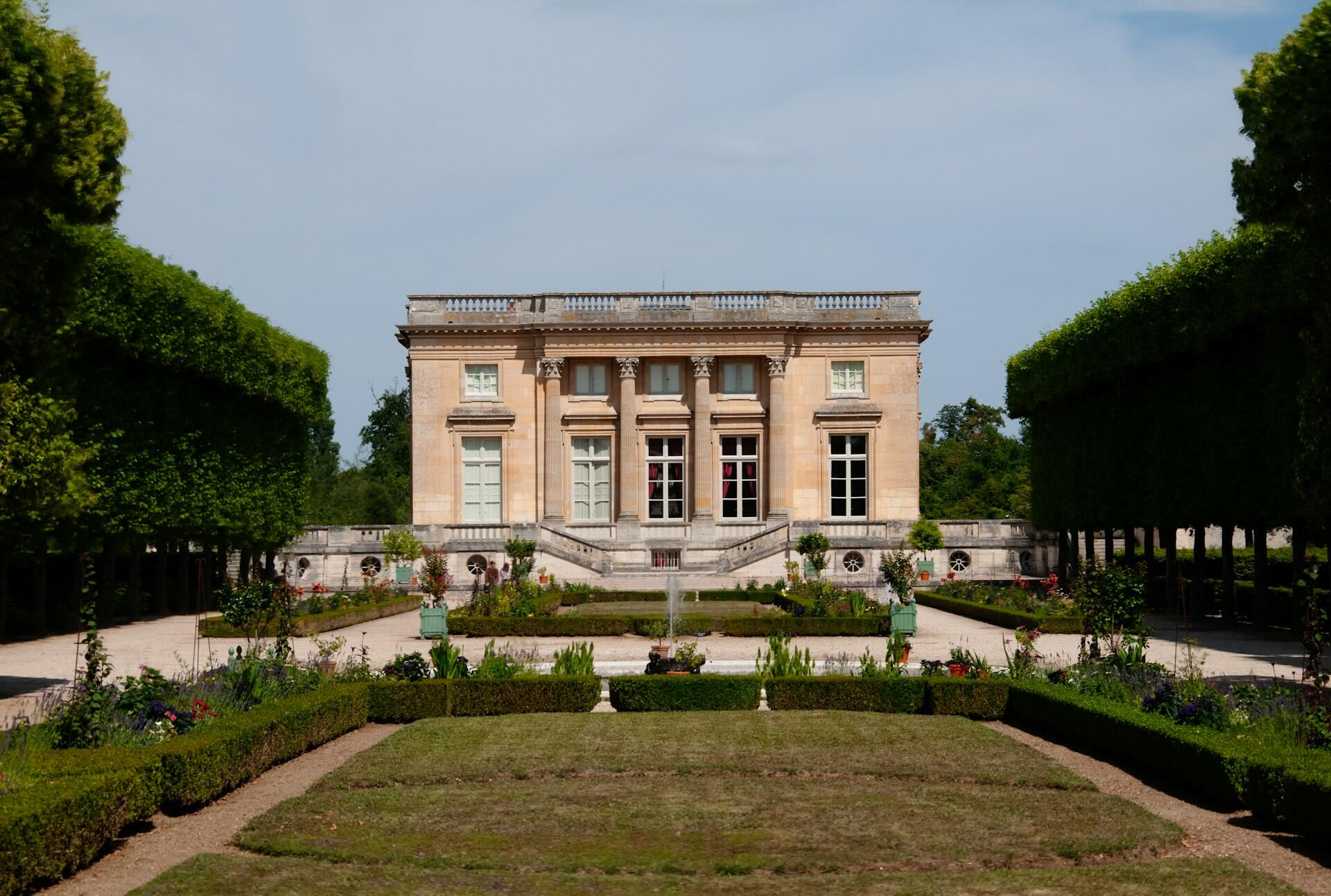 A stone building behind an expansive lawn.
