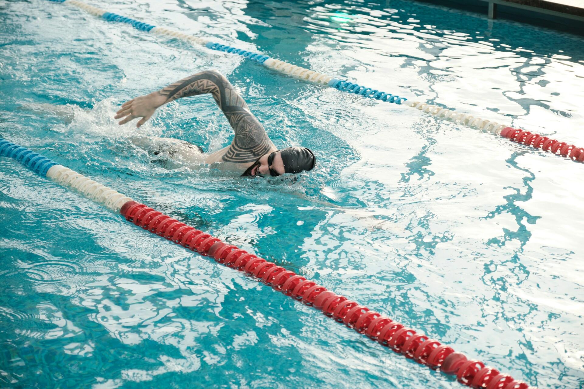 A man swimming laps in a swimming pool.