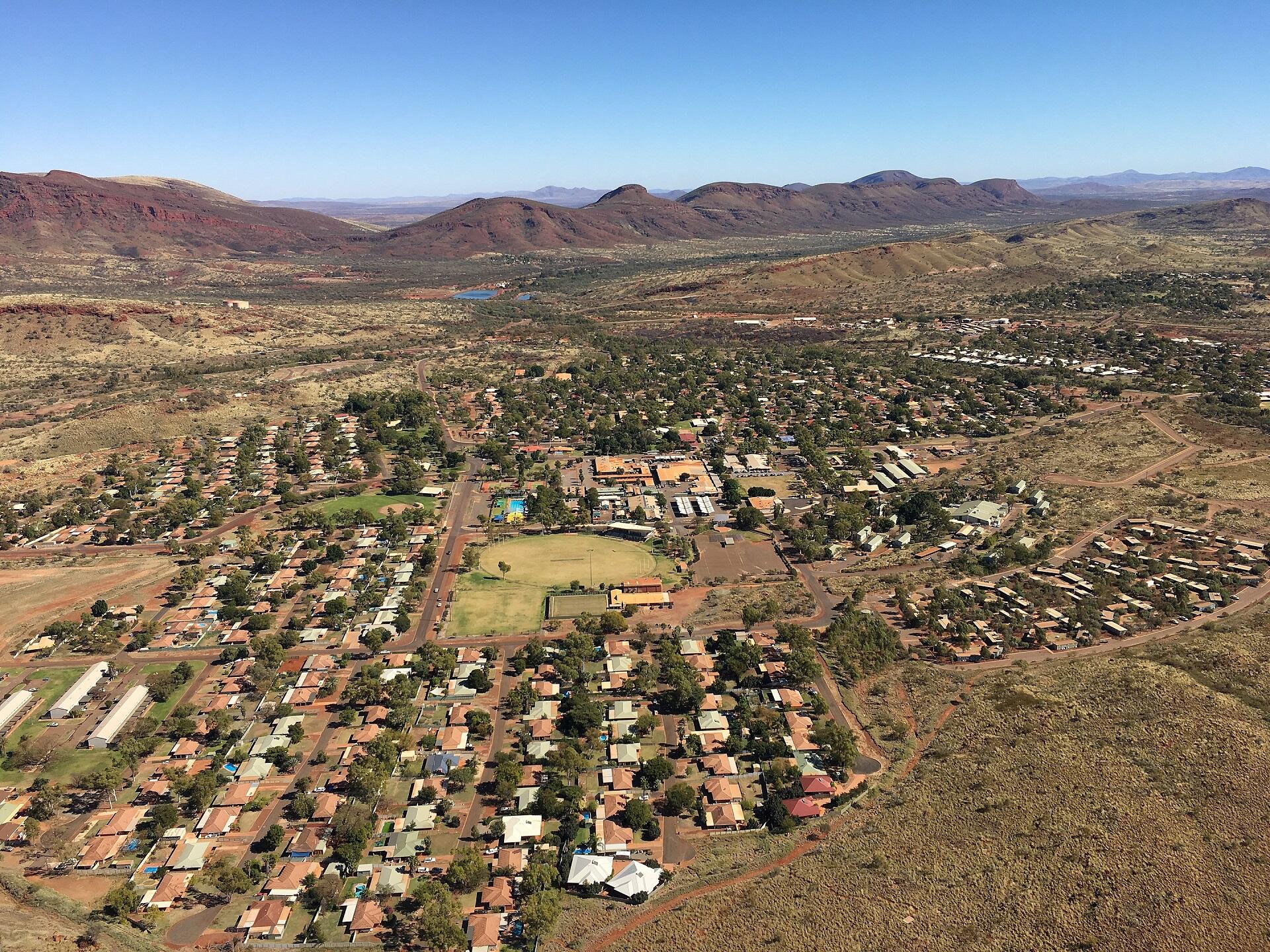 A bird's eye view of a small town surrounded by desert on a sunny day.