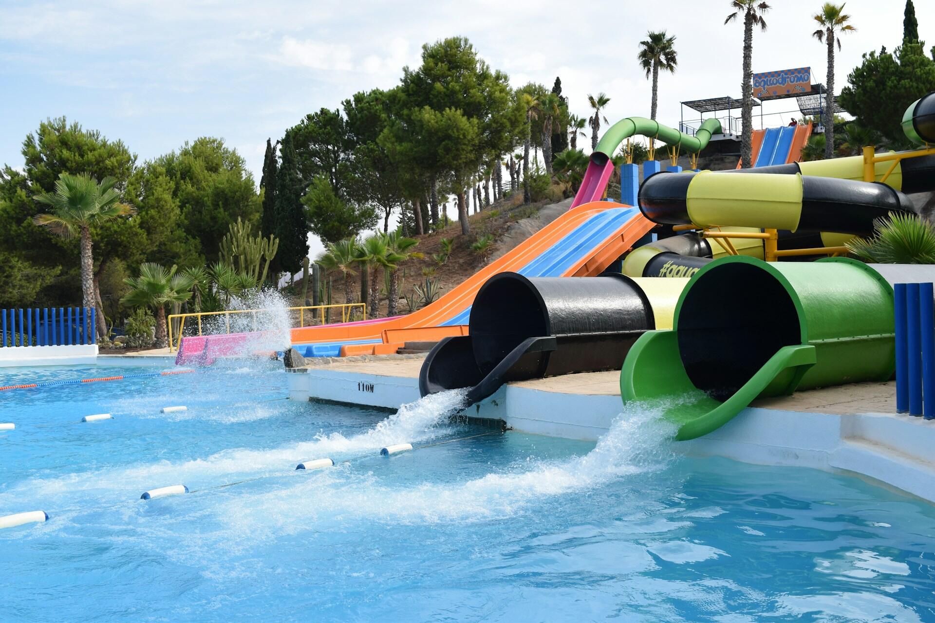 A water park with two slide gushing into the pool. 