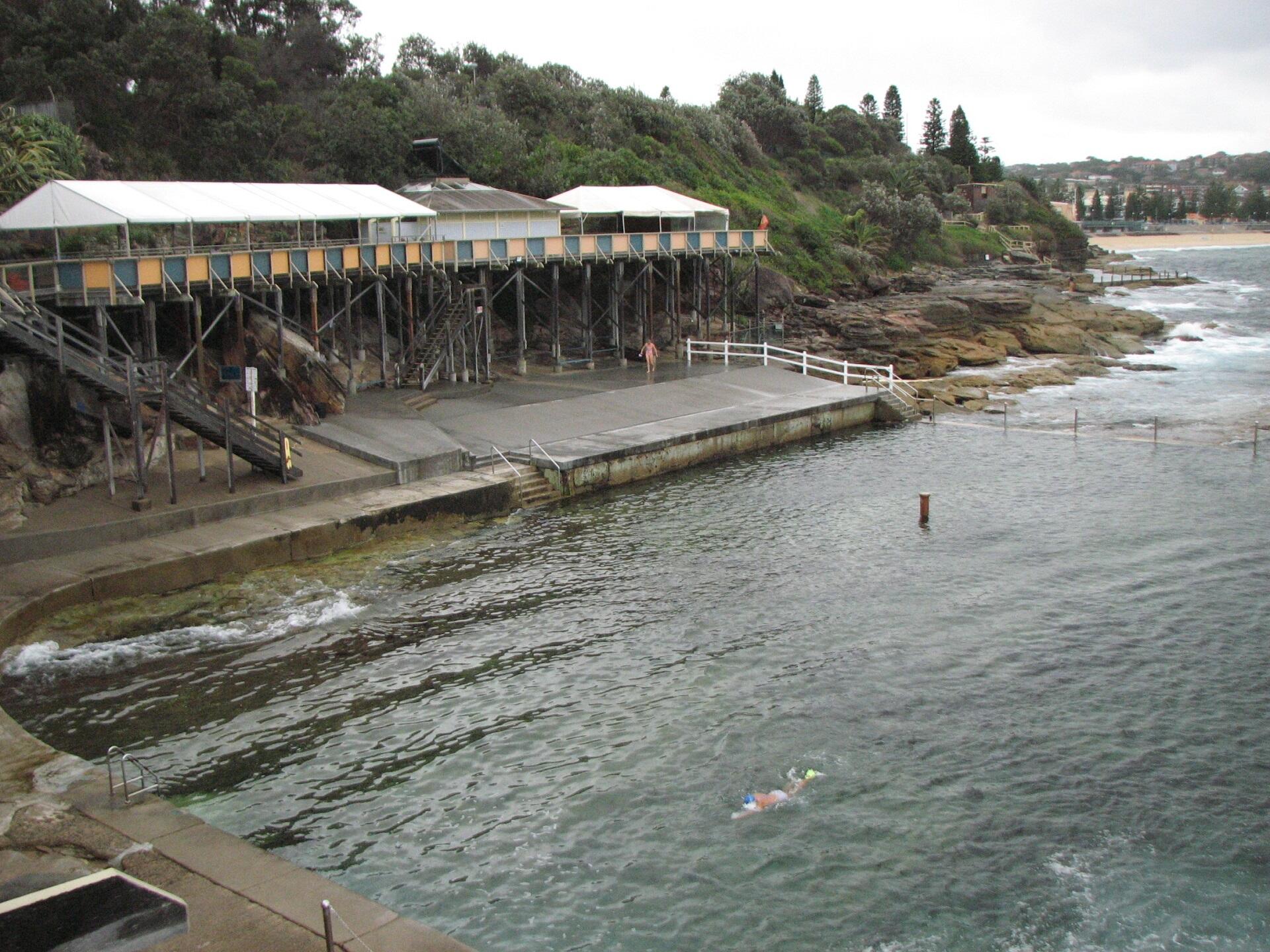 Water with a gallery on shore on a cloudy day.