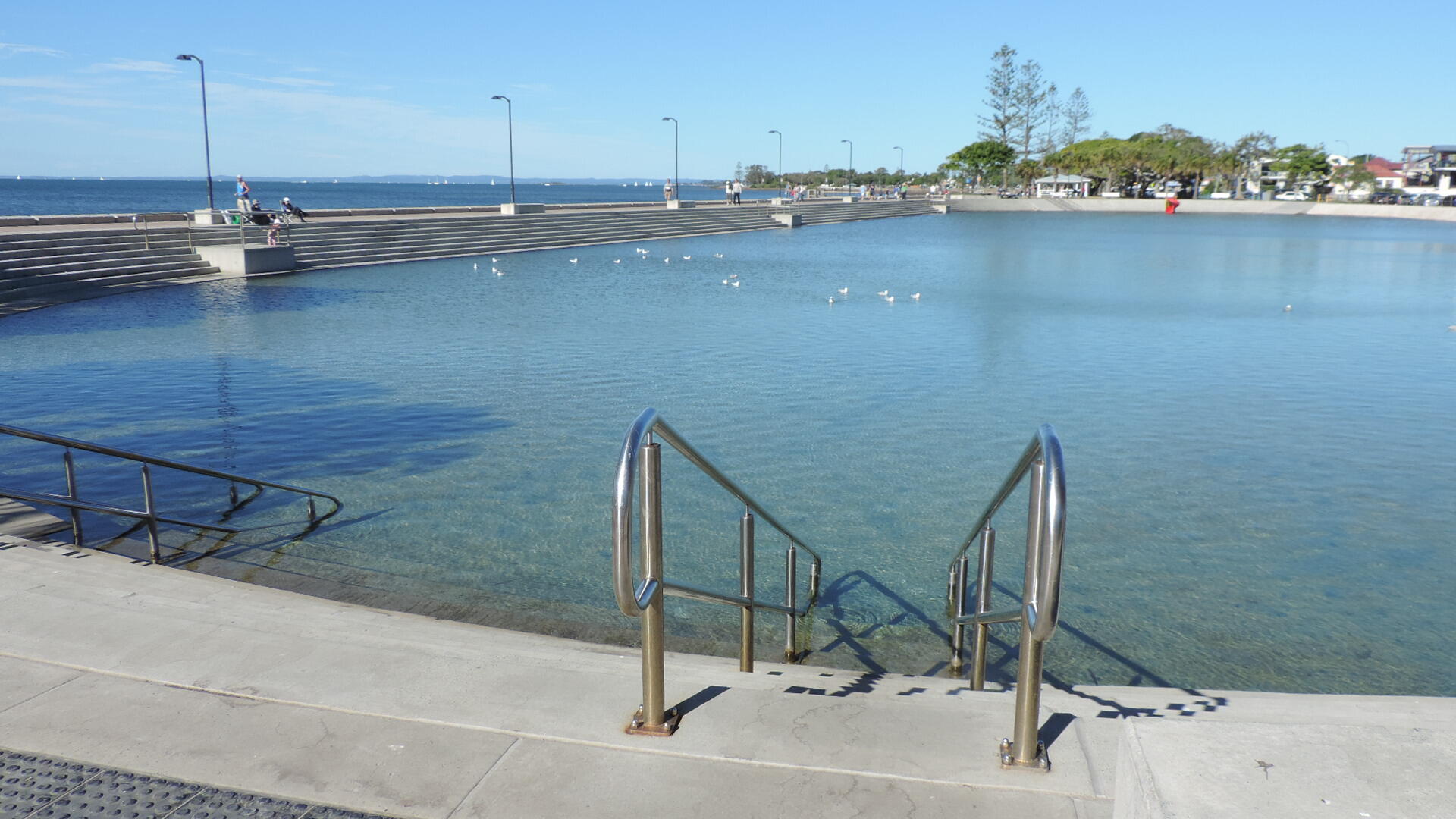 A lagoon with steps leading into it on a sunny day. 