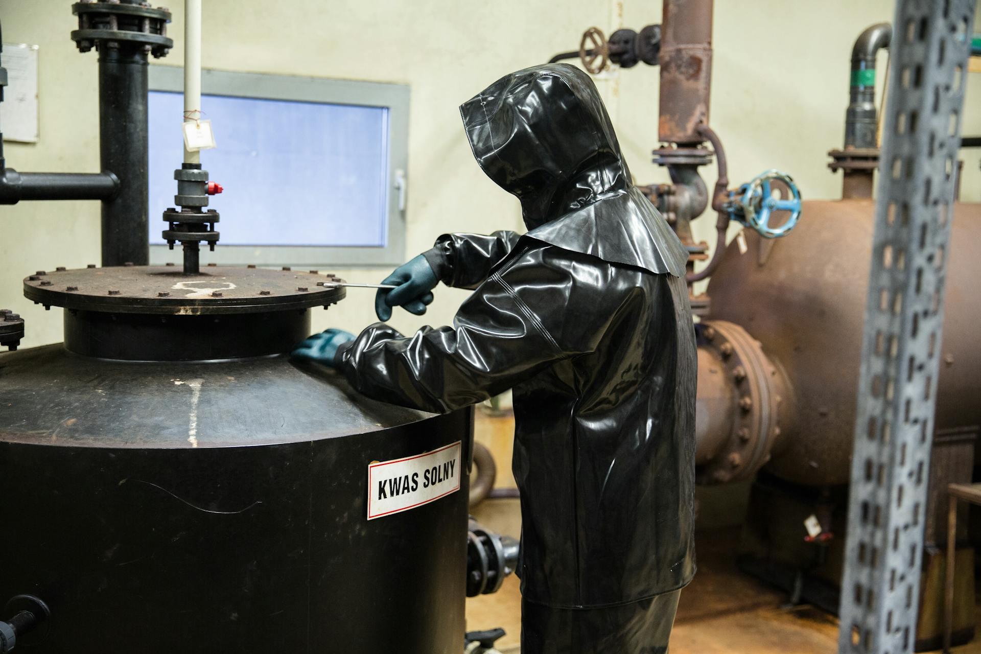 chemical engineer servicing equipment in a facility wearing a protective suit