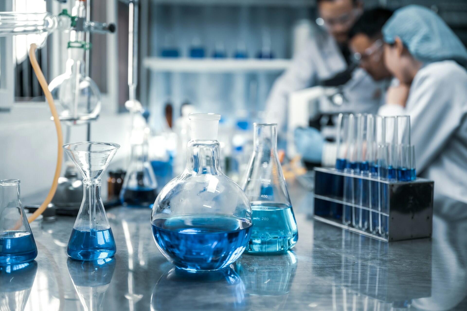 People in a chemistry lab wearing safety gear.
