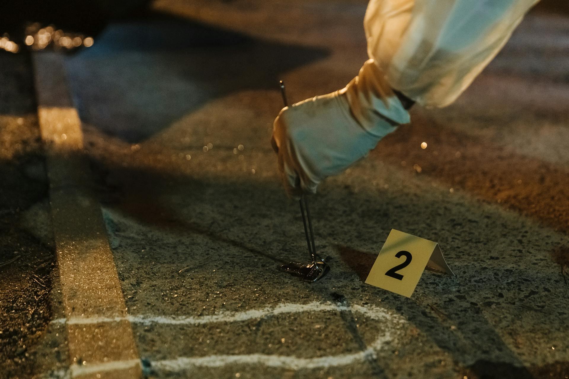 a forensic scientist at a crime scenes wearing PPE and searching for evidence