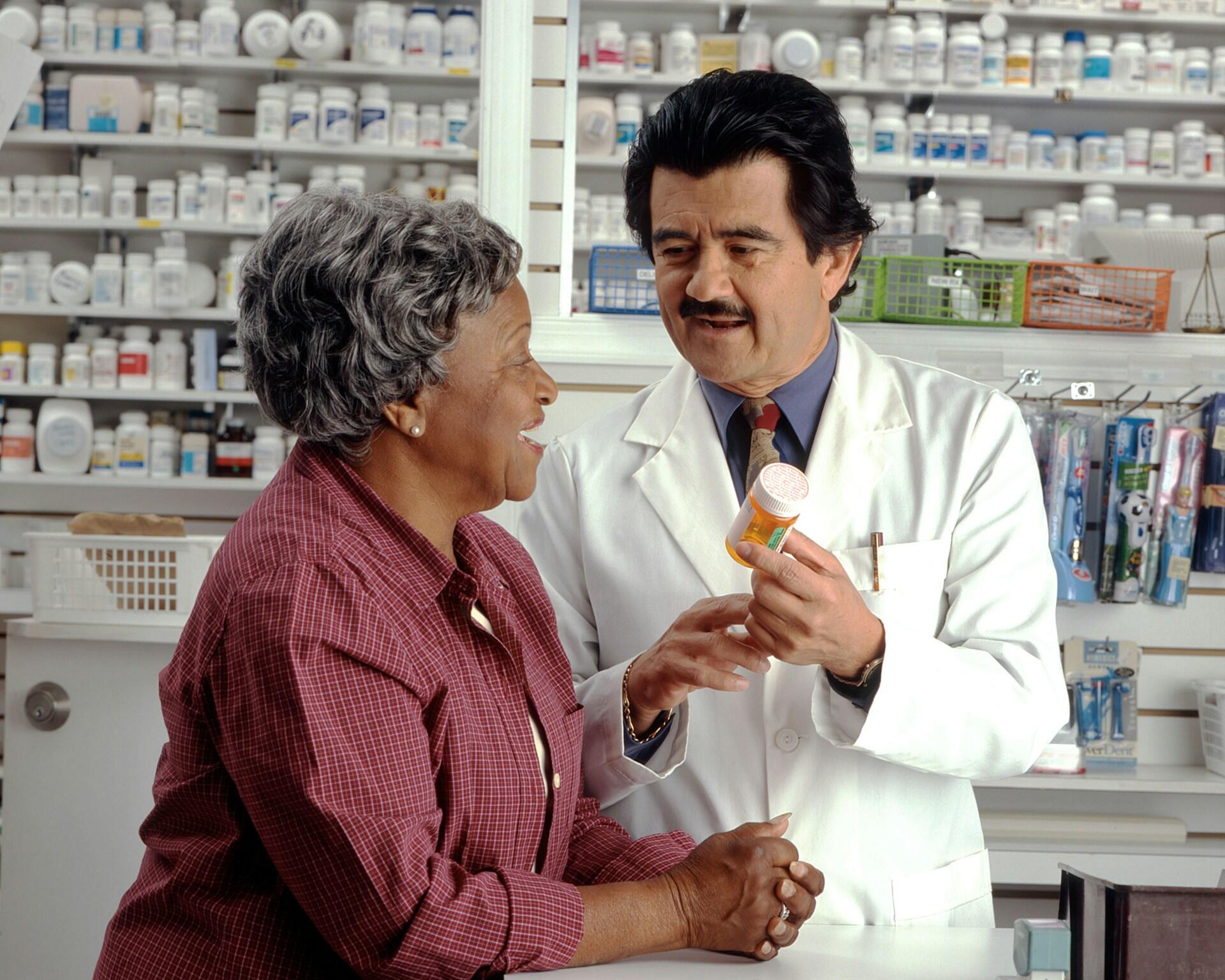 A person in a white labcoat and a woman in a red top.