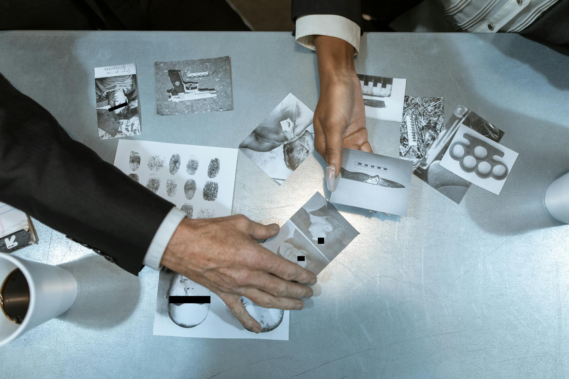 investigators sorting evidence like photos of the crime scene, suspects, and weapons