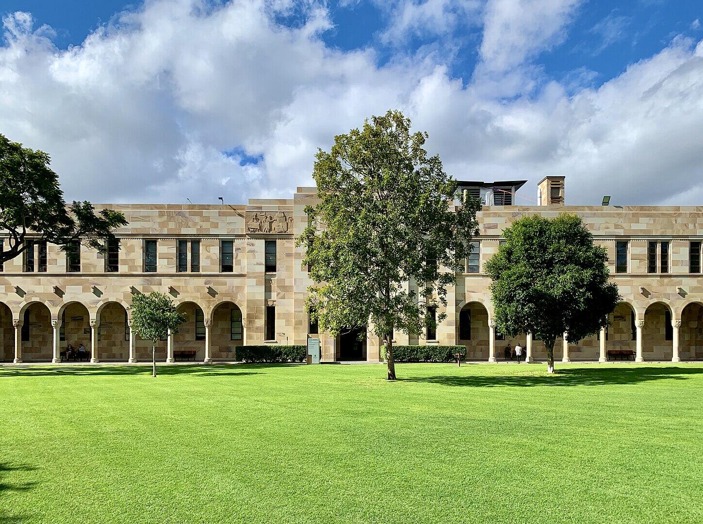 A stone building and green lawn on a sunny day.