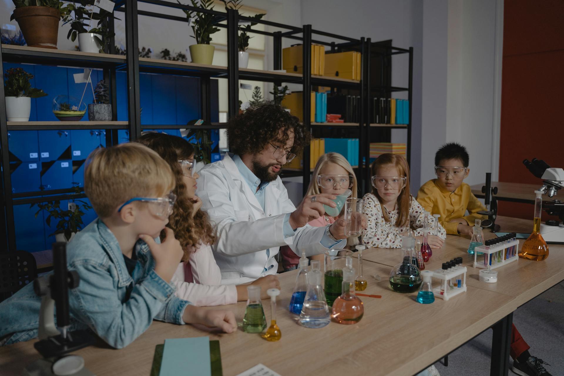 a science teacher performing an experiment for a class of young children