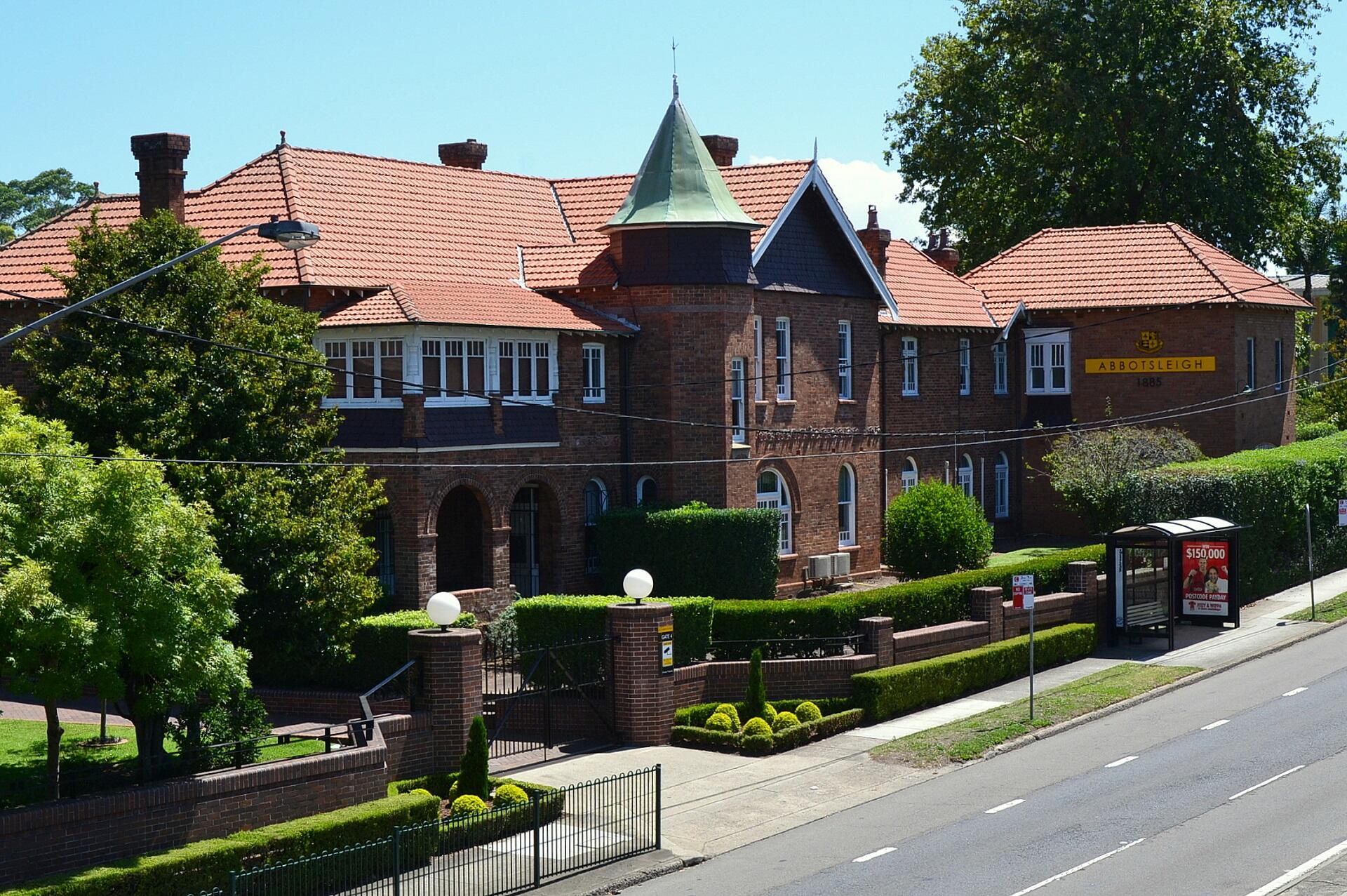 A brick building and greenery on a sunny day. 