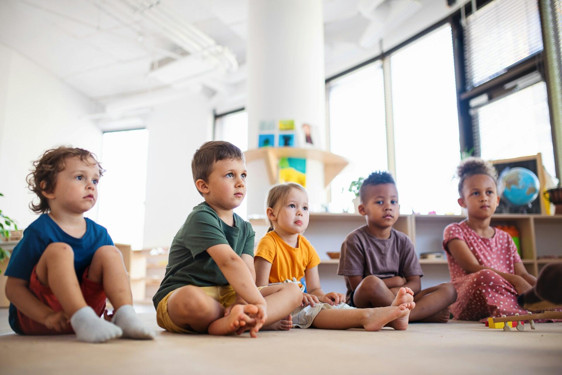 Primary school students sitting on the floor.