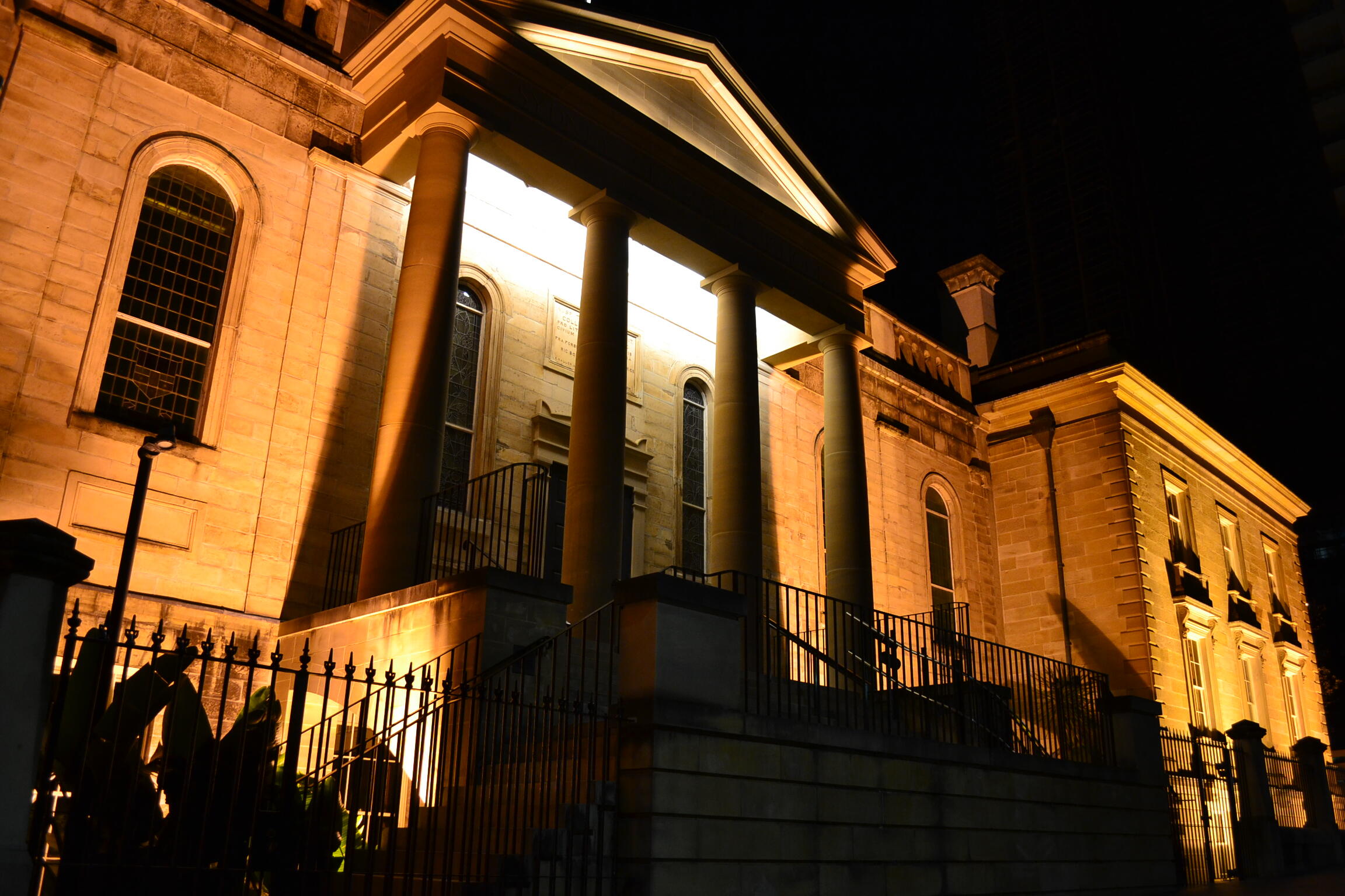 A stone building with columns lit up at night.