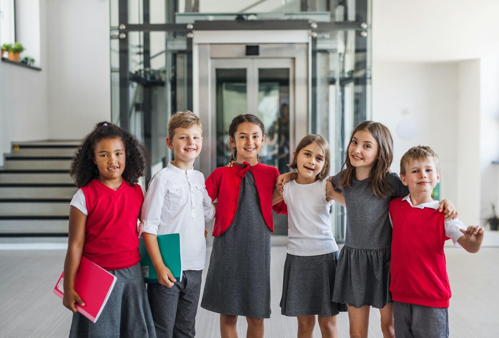 Six students wearing red and grey school uniforms. 