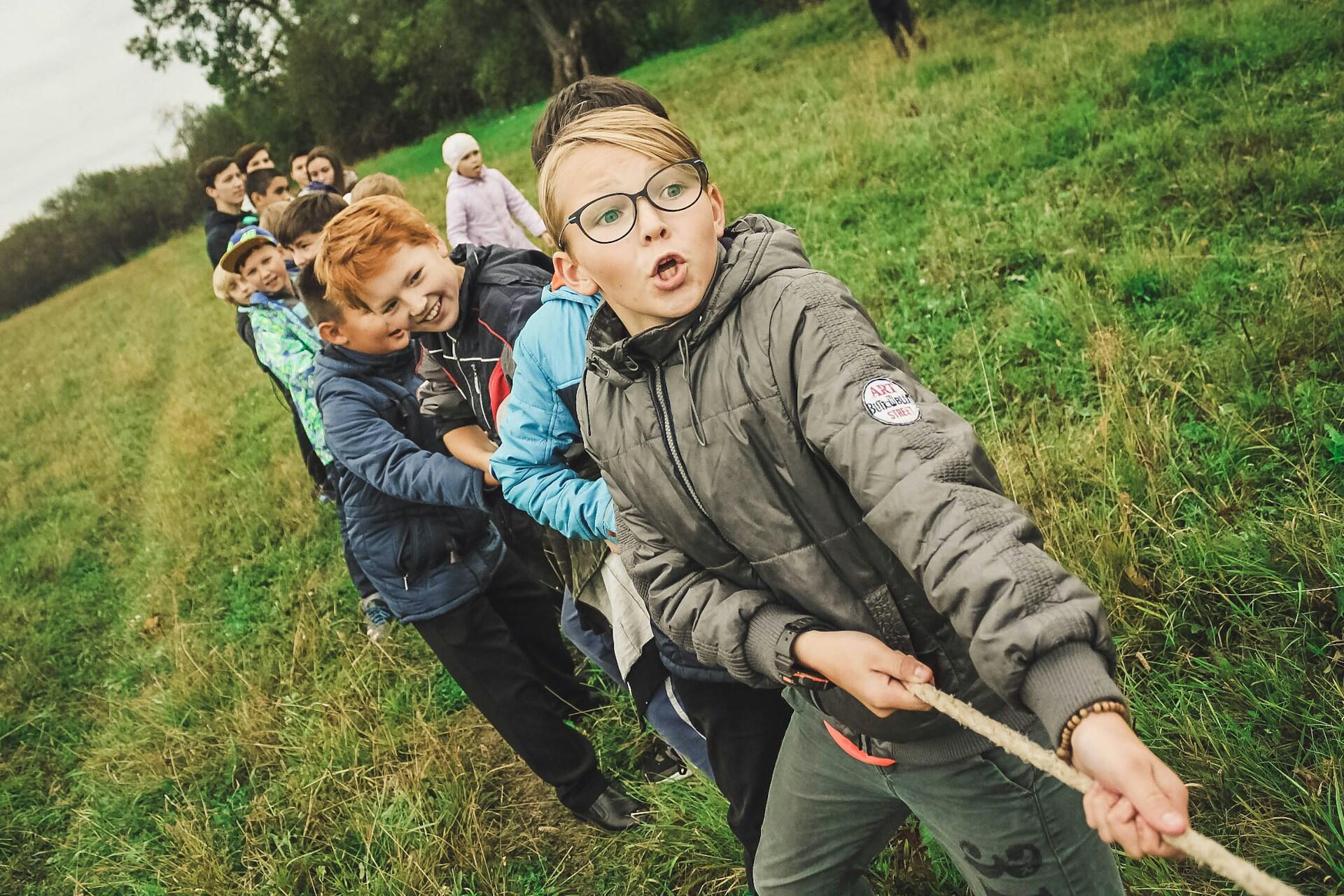 Children outdoors playing tug-of-war.