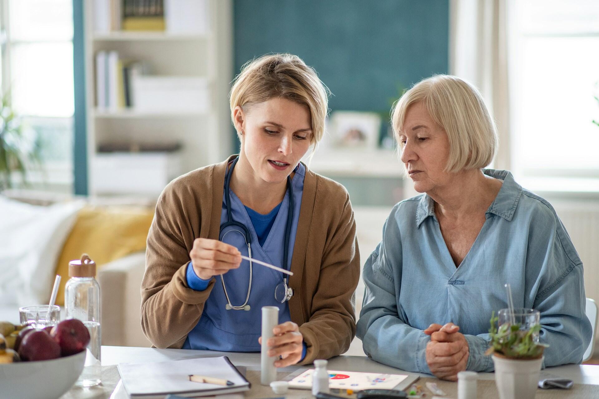 Female nurse looking at test results with an elderly patient.