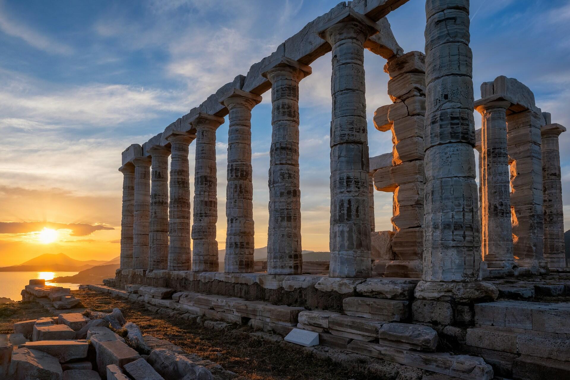 greek pillar archaeological site over sunset.