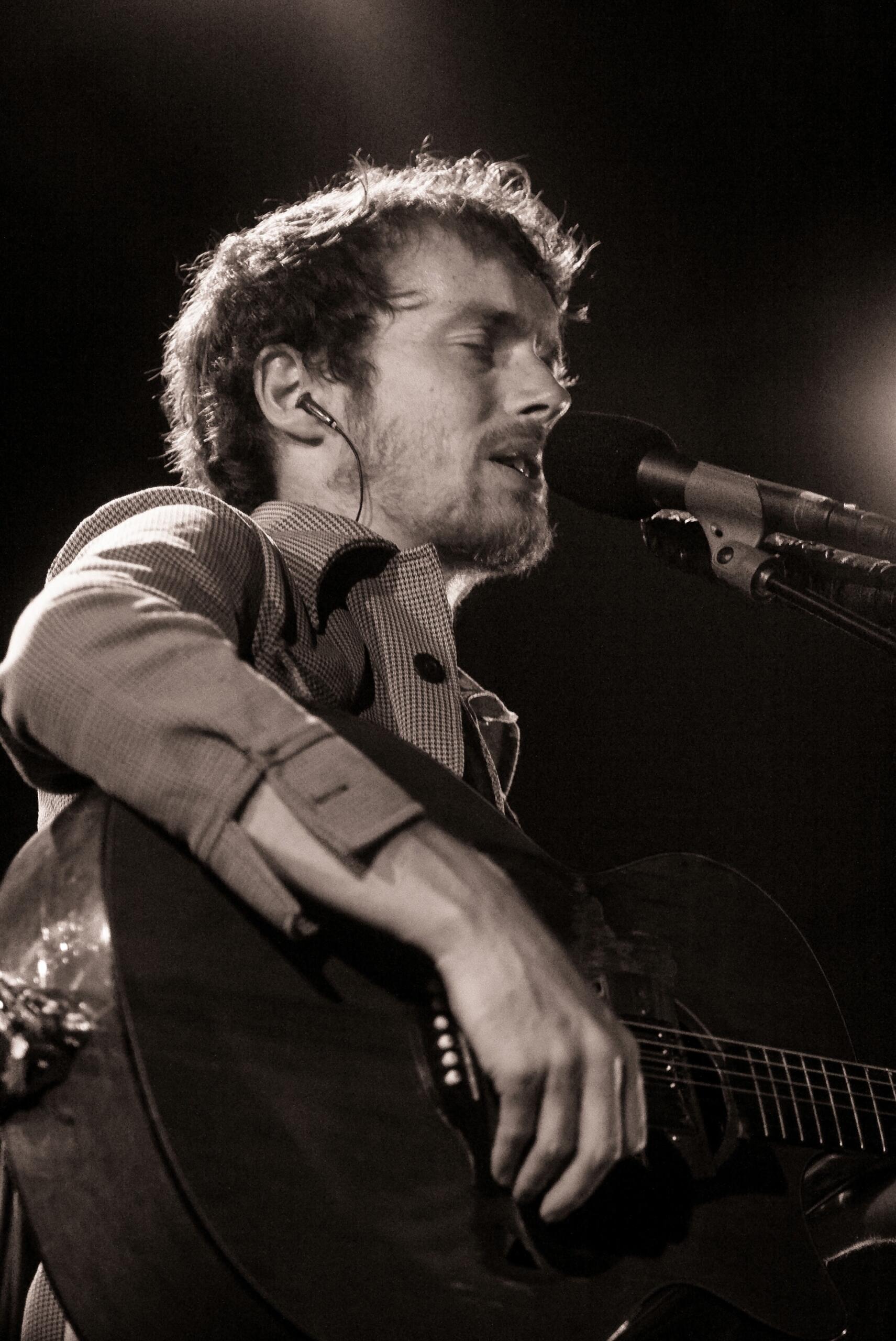 Irish musician Damien Rice performing on stage.