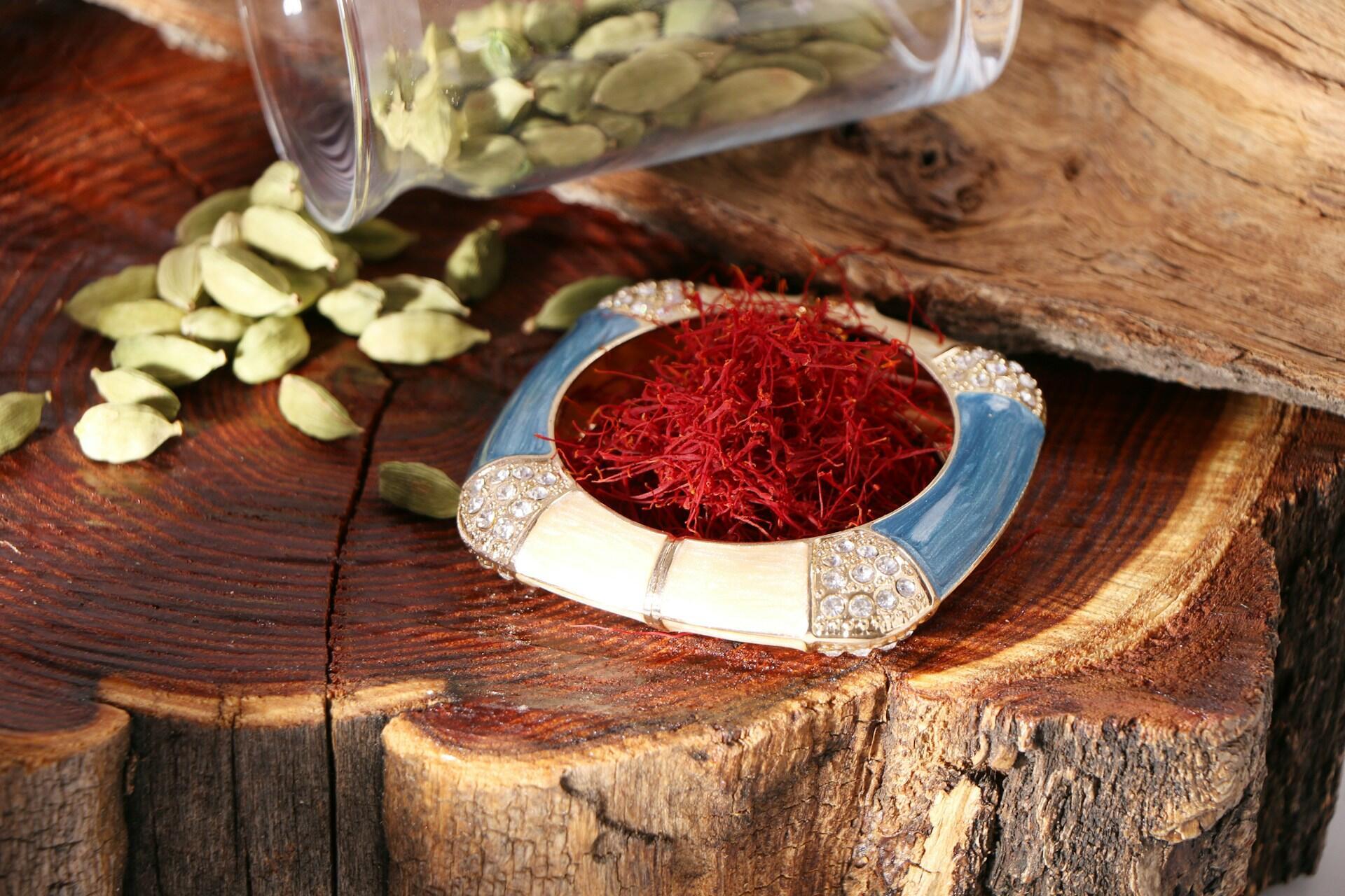 red saffron threads in a bowl on a polished piece of wood