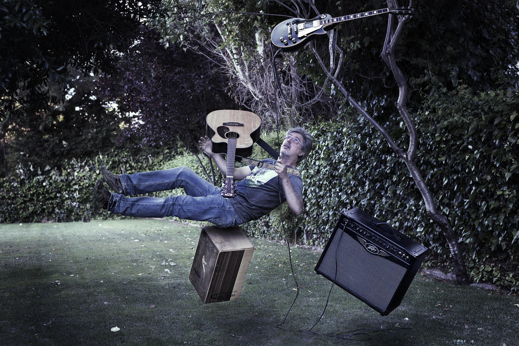 A guitarist with amps and two guitars - all floating in the air. 