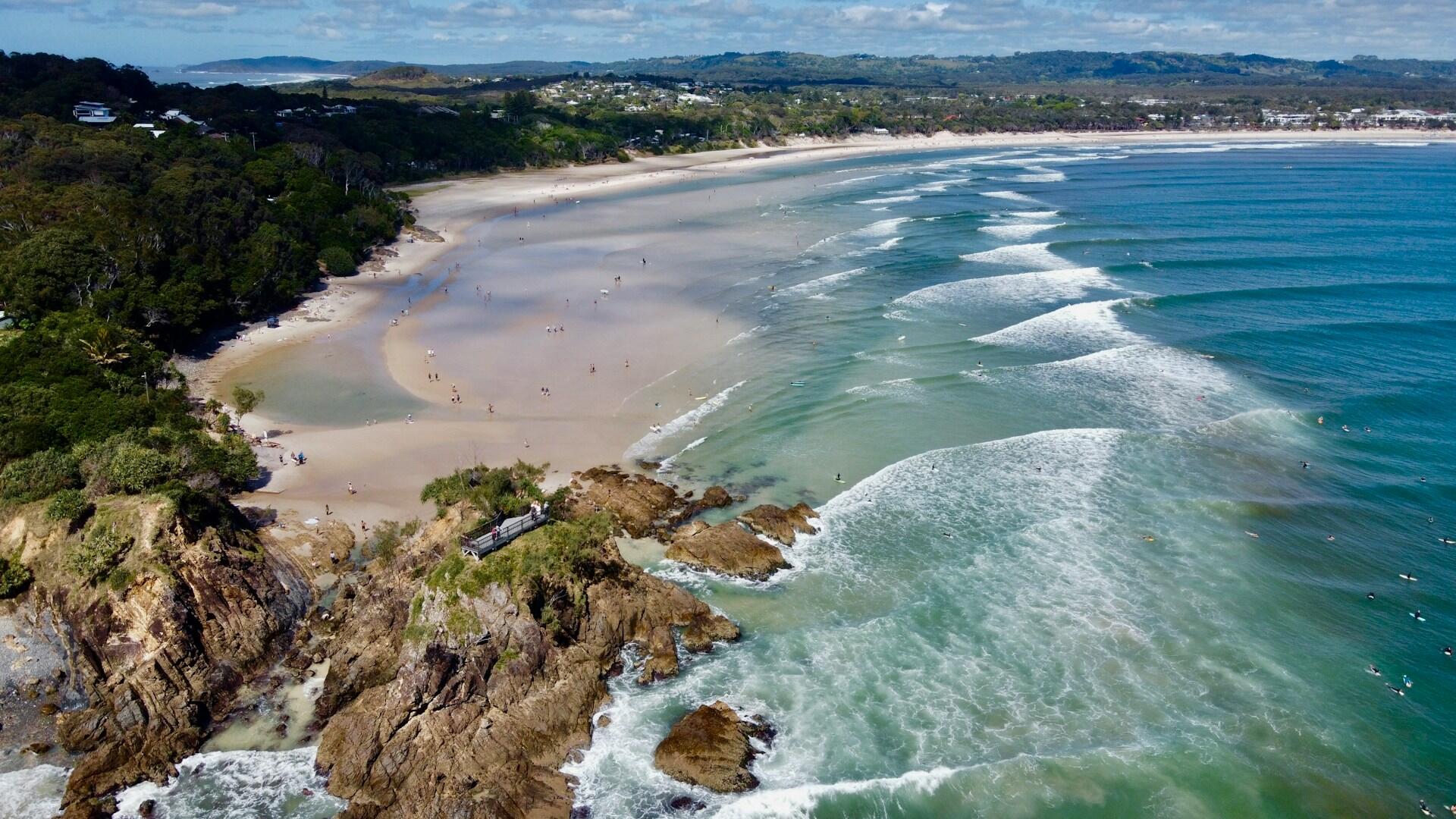 Aerial view of a picturesque beach with clear turquoise waters and sandy shores.