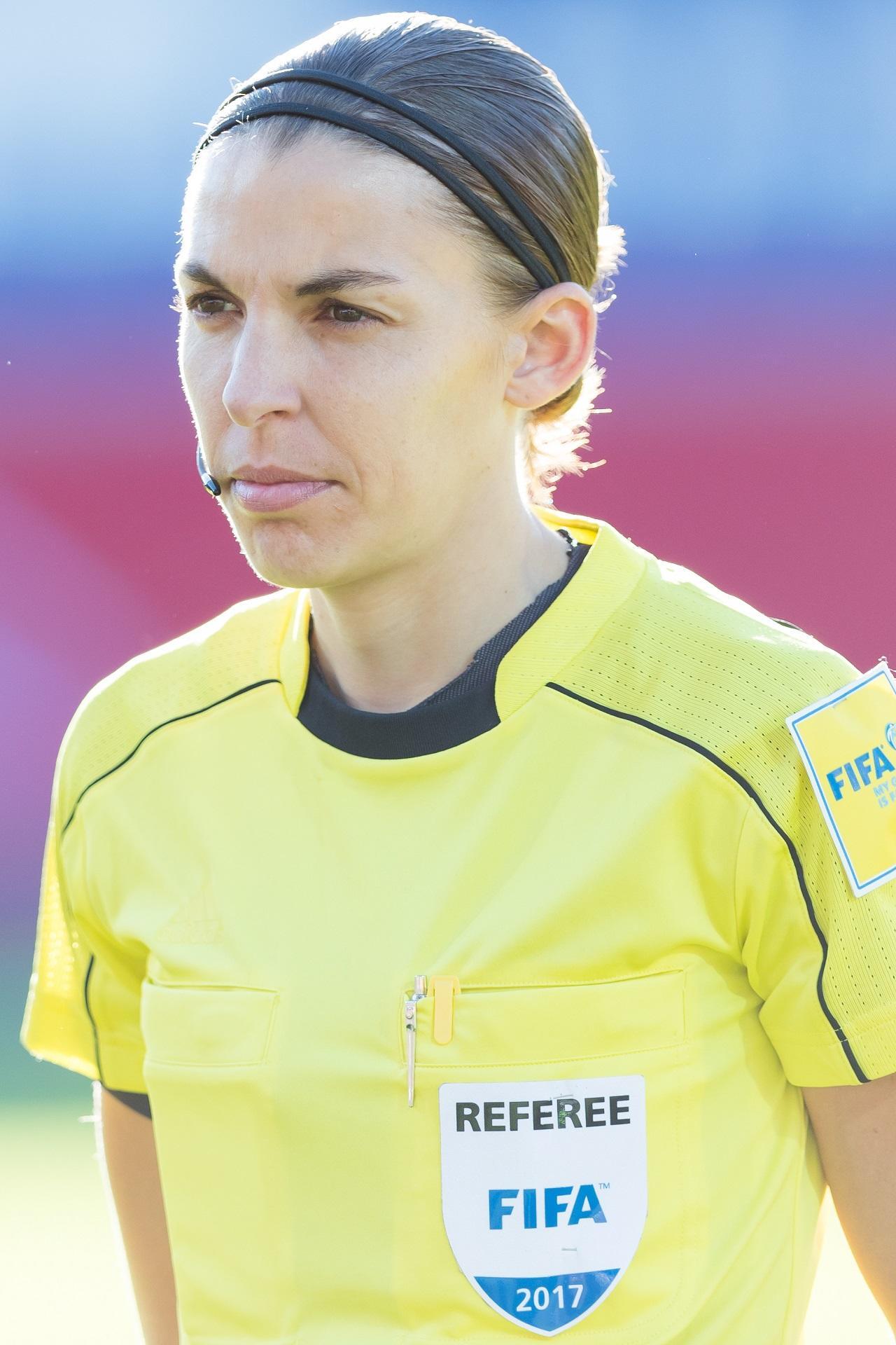 A woman in a bright yellow sports jersey on a sunny day.