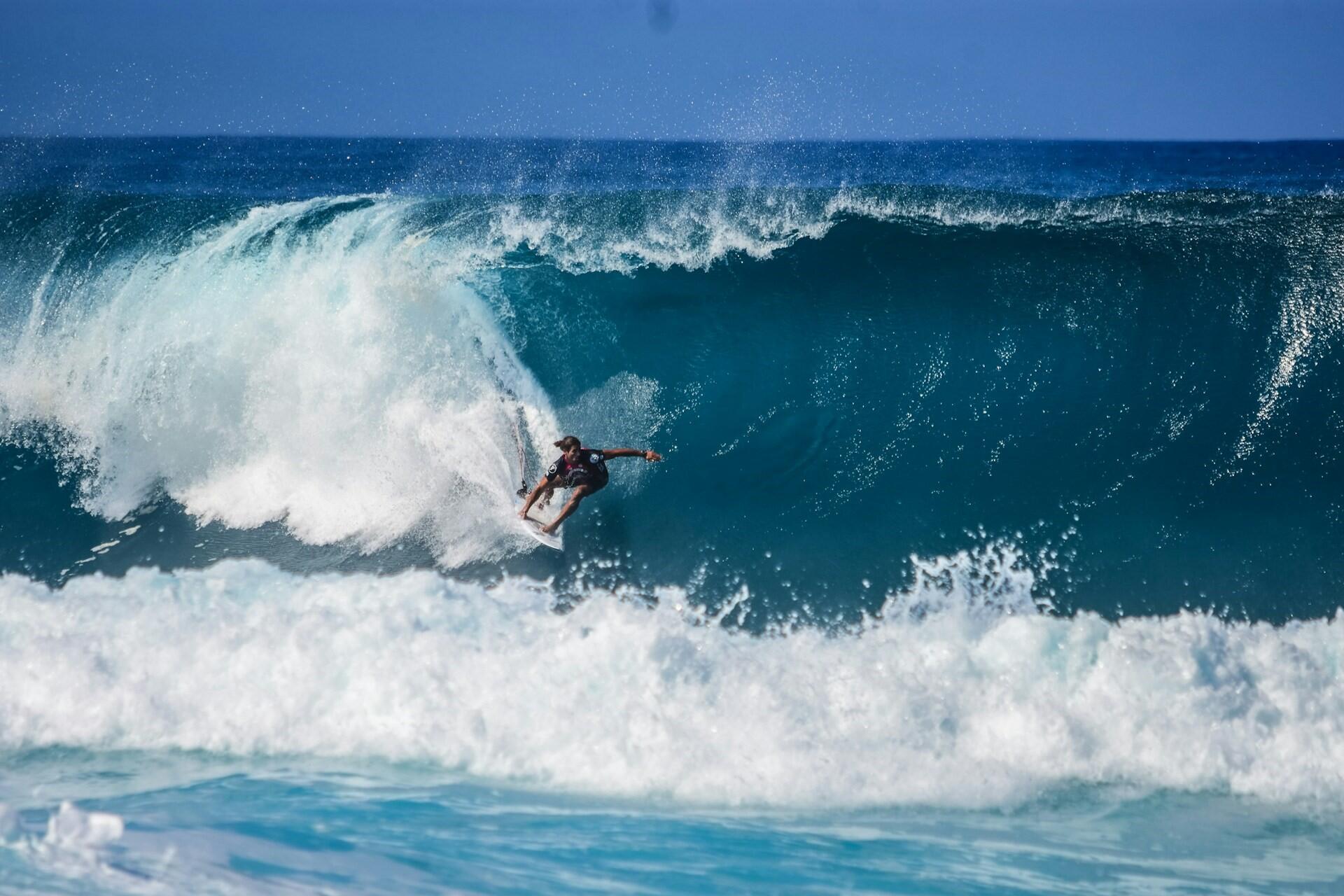 A man surfing on a big wave.