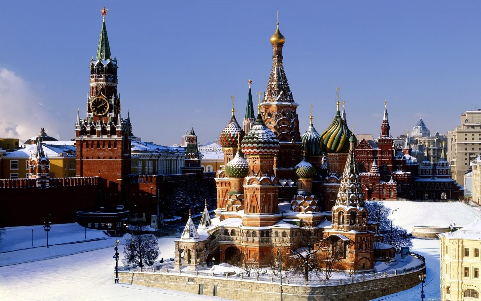 Snow-covered Red Square featuring St. Basil's Cathedral and the Kremlin's tower.