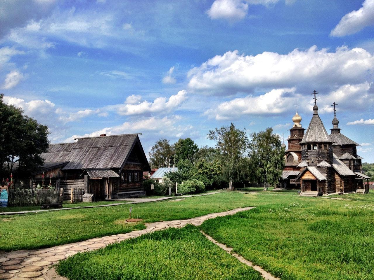 A picturesque scene featuring a wooden church and traditional cottages.
