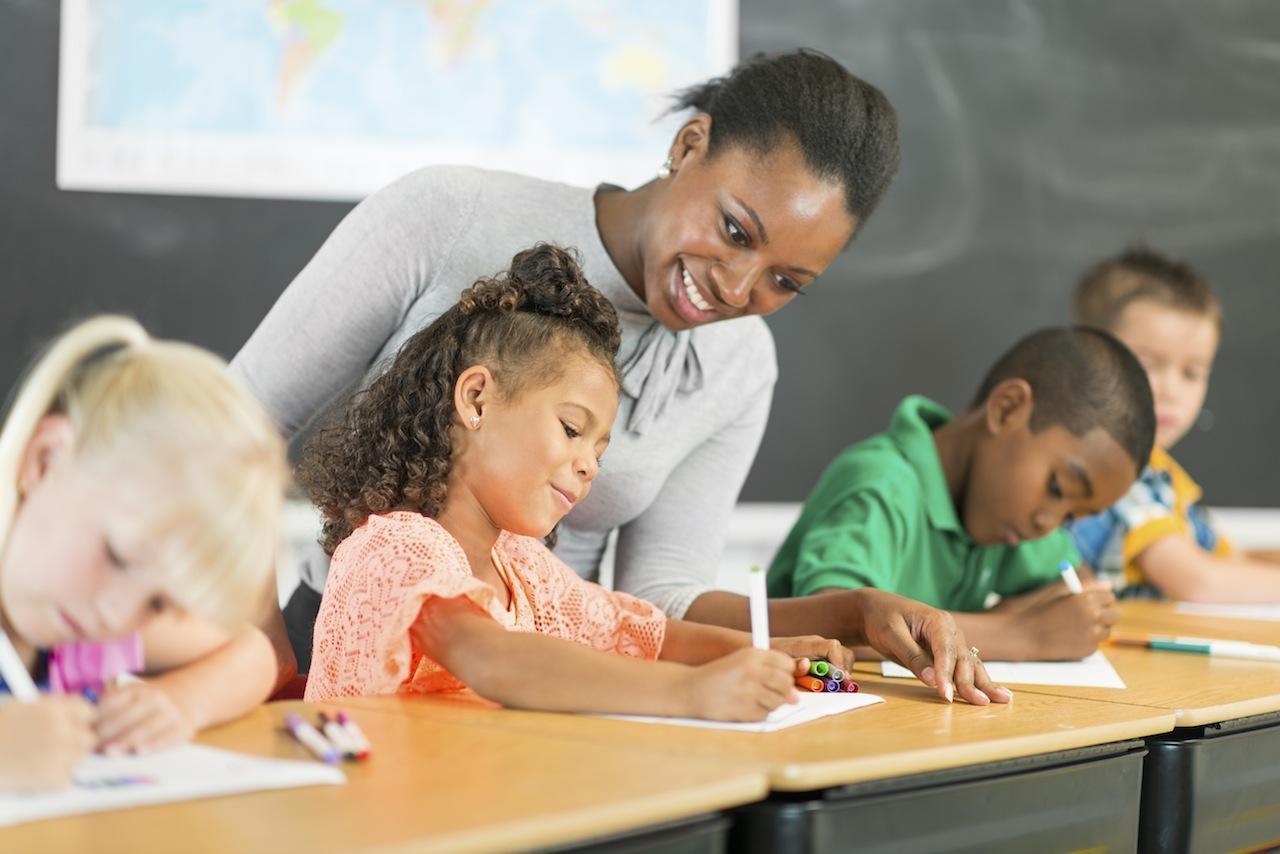 A teacher assists students in a classroom.