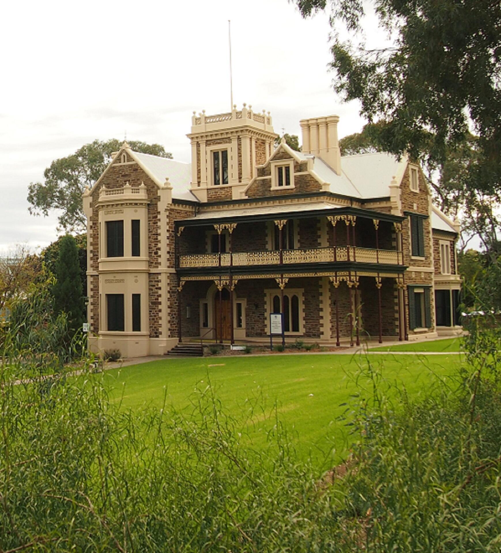 An old-style house in the middle of a green field.